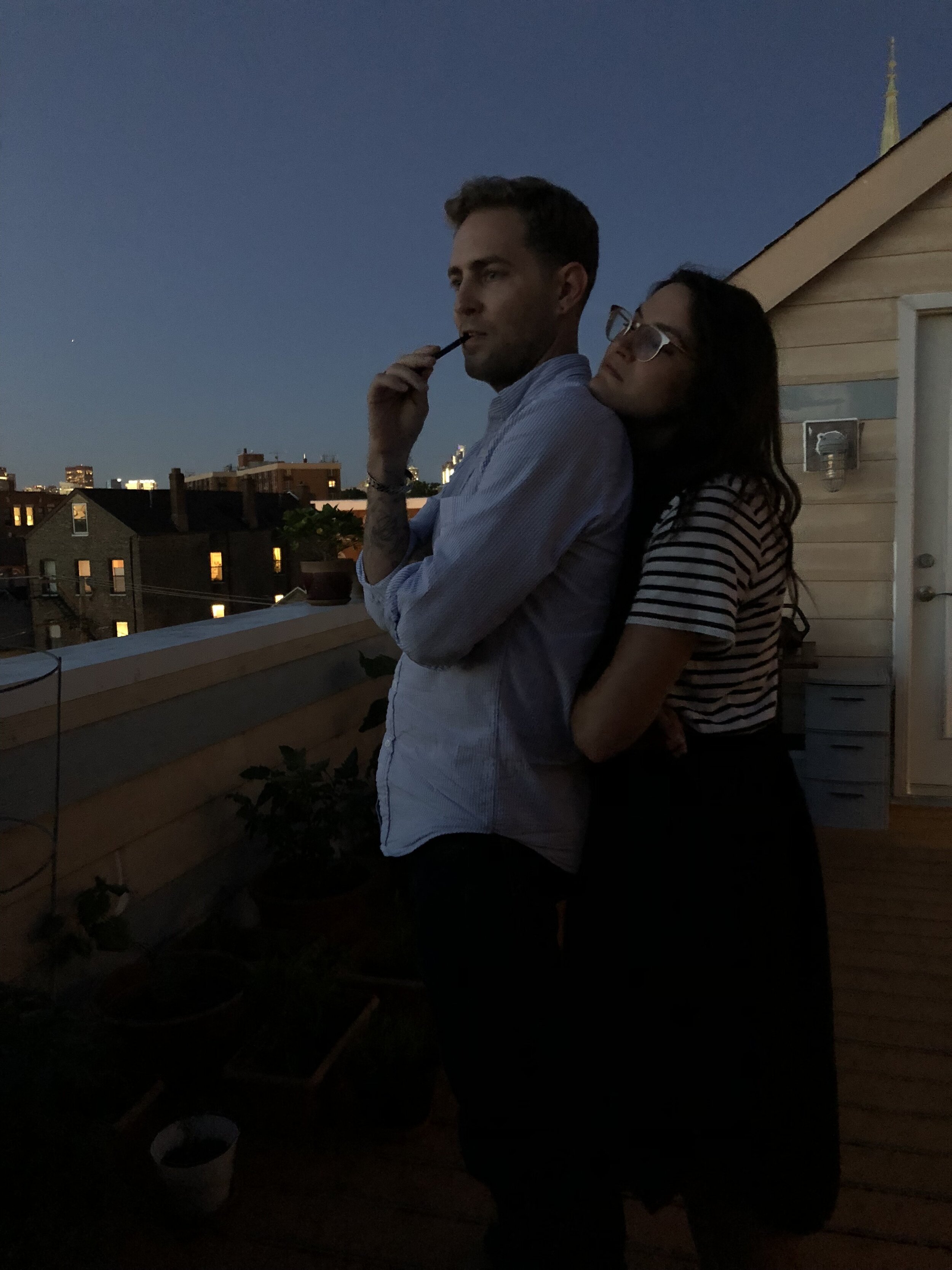 Chicago, IL. Partners in crime take in the city view from their balcony.