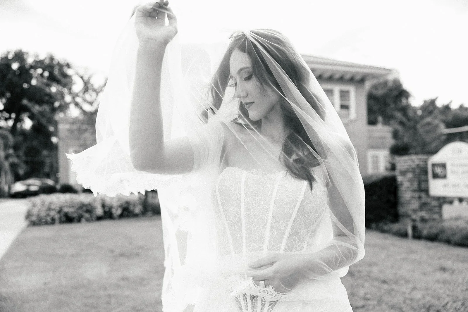 Bride wearing a strapless lace corset wedding dress and sheer veil, featured by Bridal Gown Studio San Jose.