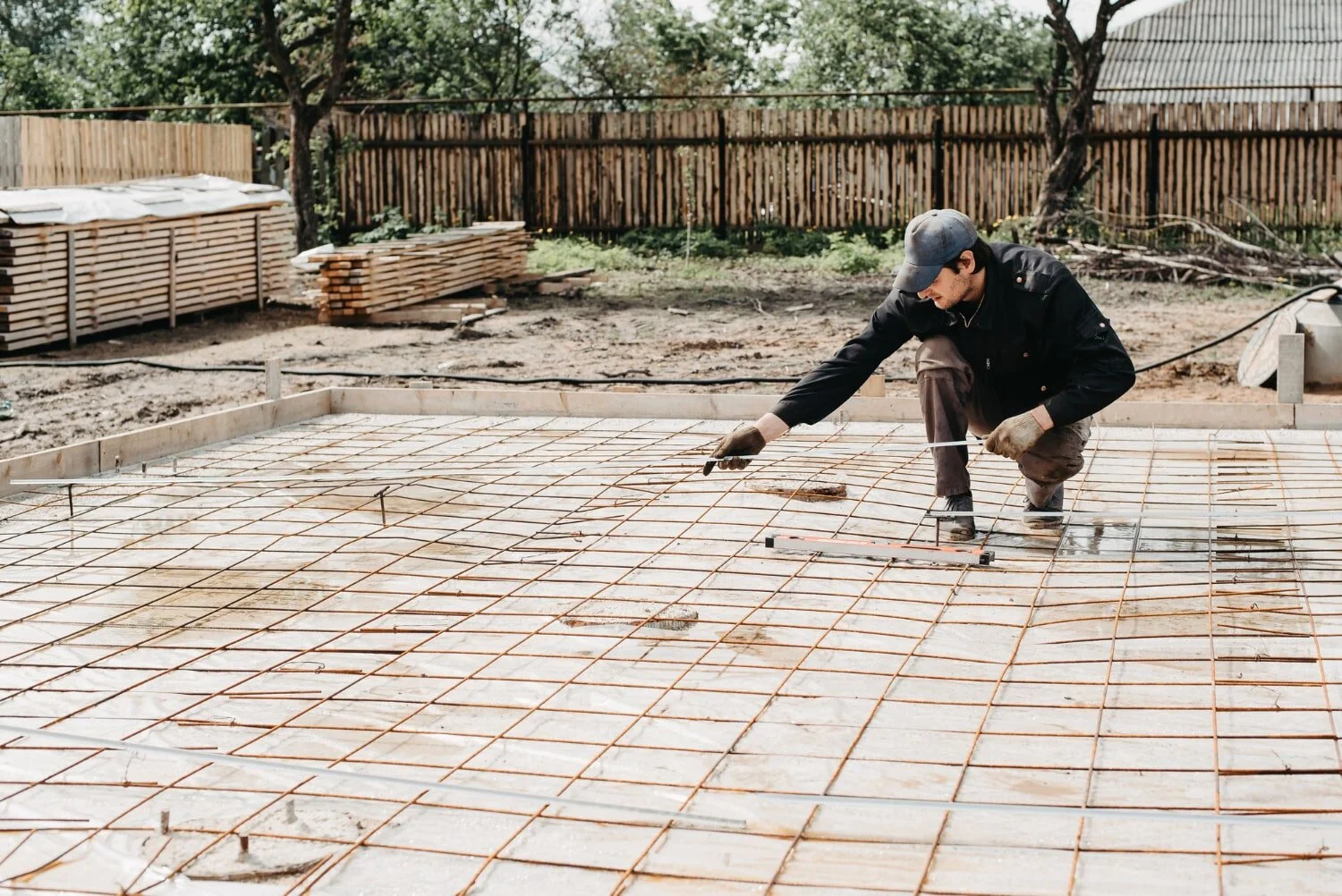 male-construction-worker-installs-metal-fittings-foundation-construction-house-pouring-concrete-min.jpg