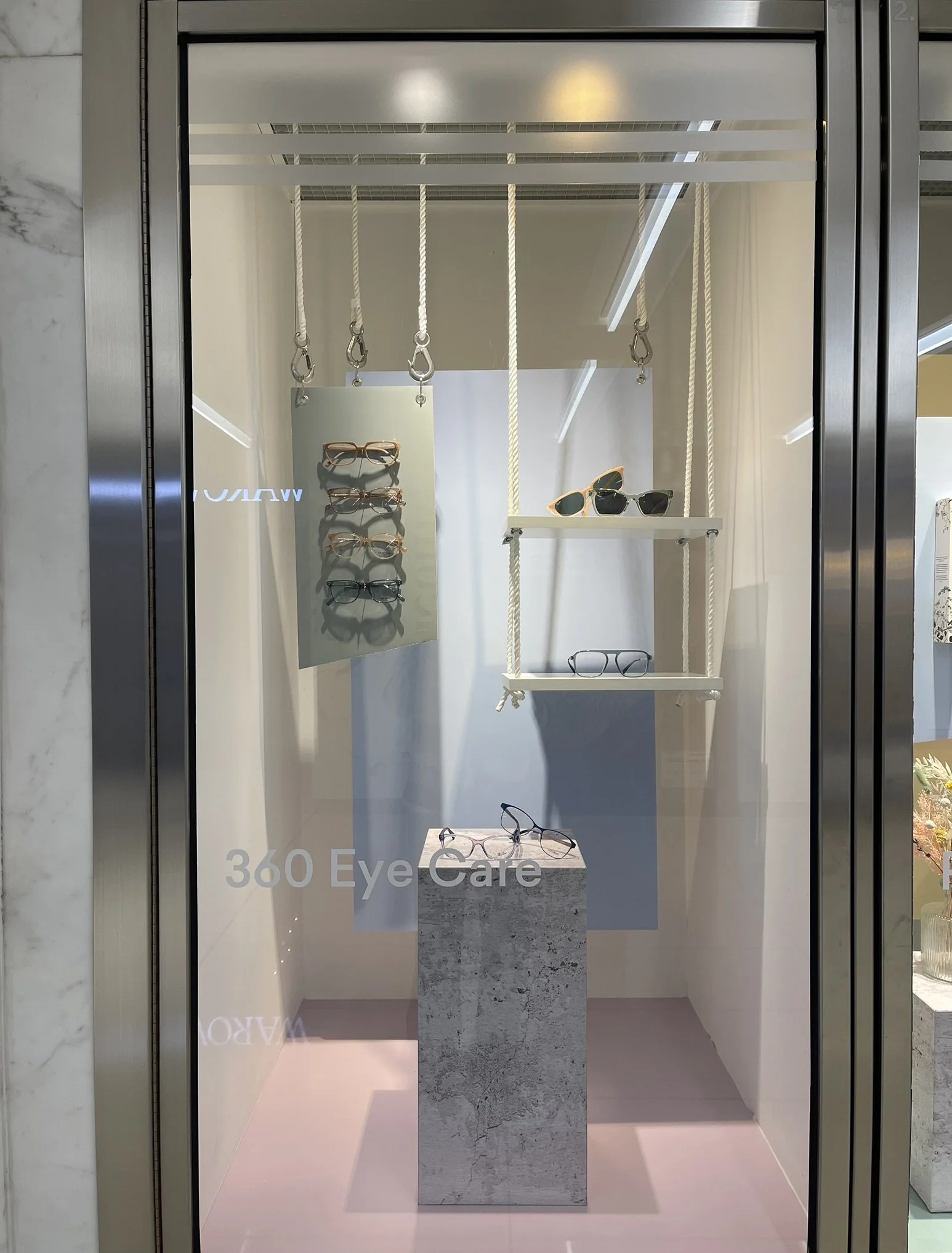 Retail window display for 360 Eye Care at Manulife Centre, highlighting eyewear through a clean, modern visual merchandising concept tailored for a multi-tenant shopping centre.