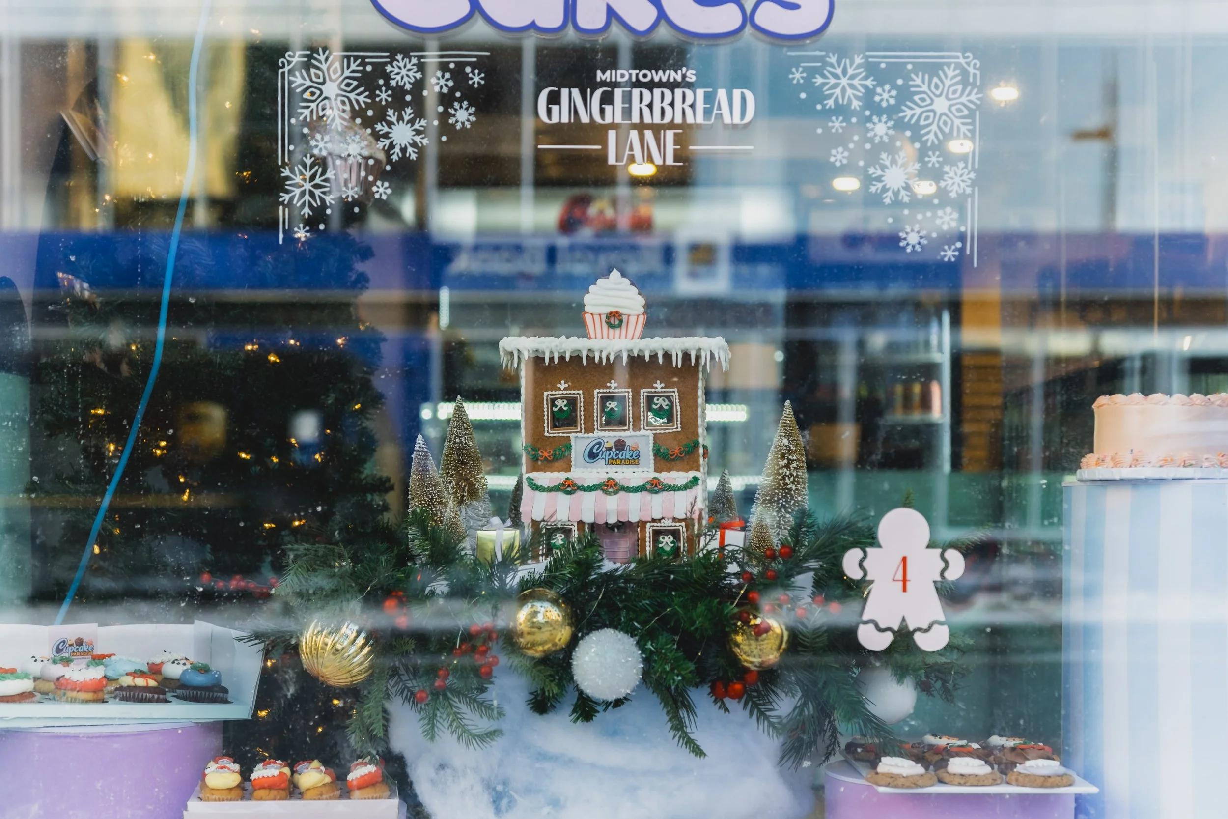 Holiday window display featuring a gingerbread house installation with snowflake window decals for Midtown’s Gingerbread Lane at Yonge St. Clair BIA in Toronto.