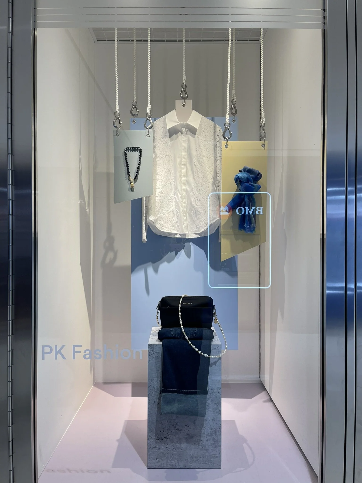 Alternate view of PK Fashion’s window display at Manulife Centre, designed to integrate seamlessly into a cohesive, property-led visual merchandising program.