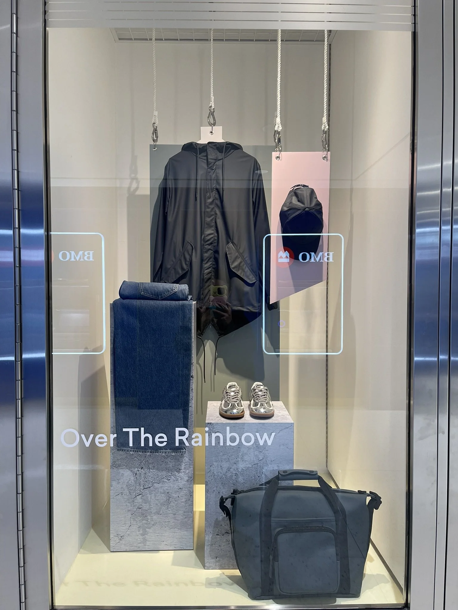 Retail window display for Over The Rainbow at Manulife Centre, featuring apparel and accessories styled to align with a centre-wide multi-brand visual merchandising theme.