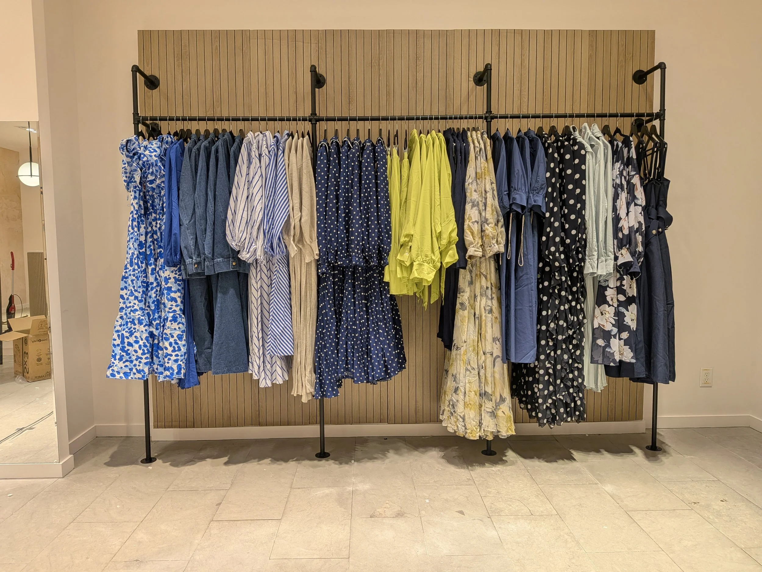 Women’s fashion wall display at Aimee Boutique organized by colour and category to improve product visibility and boutique shopability.