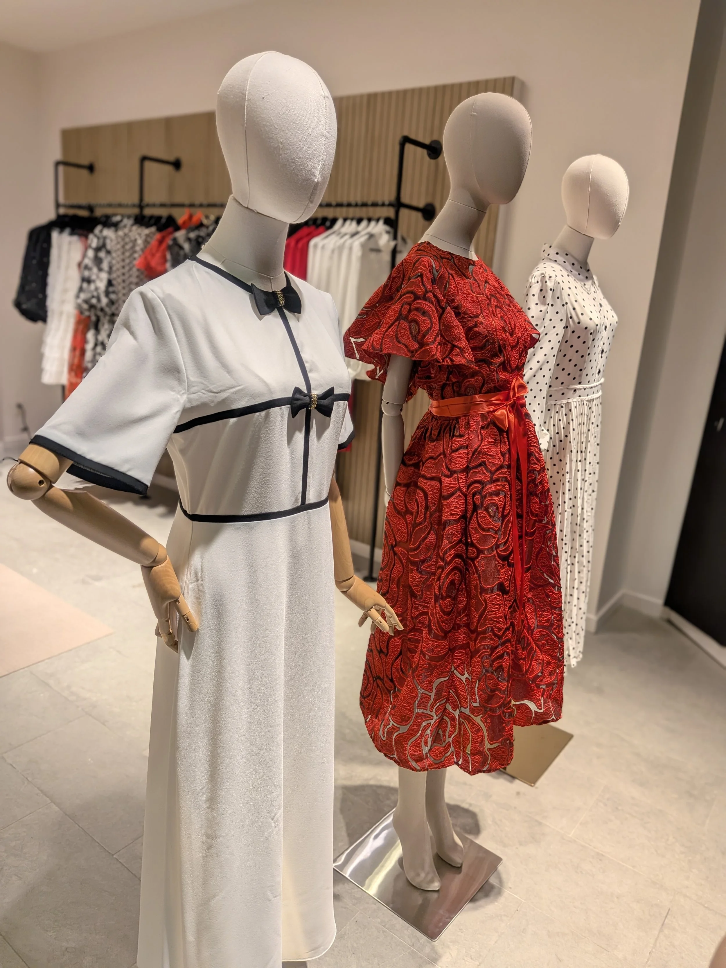 Mannequin styling and seasonal lifestyle merchandising at Aimee Boutique women’s clothing store featuring curated dress collections.