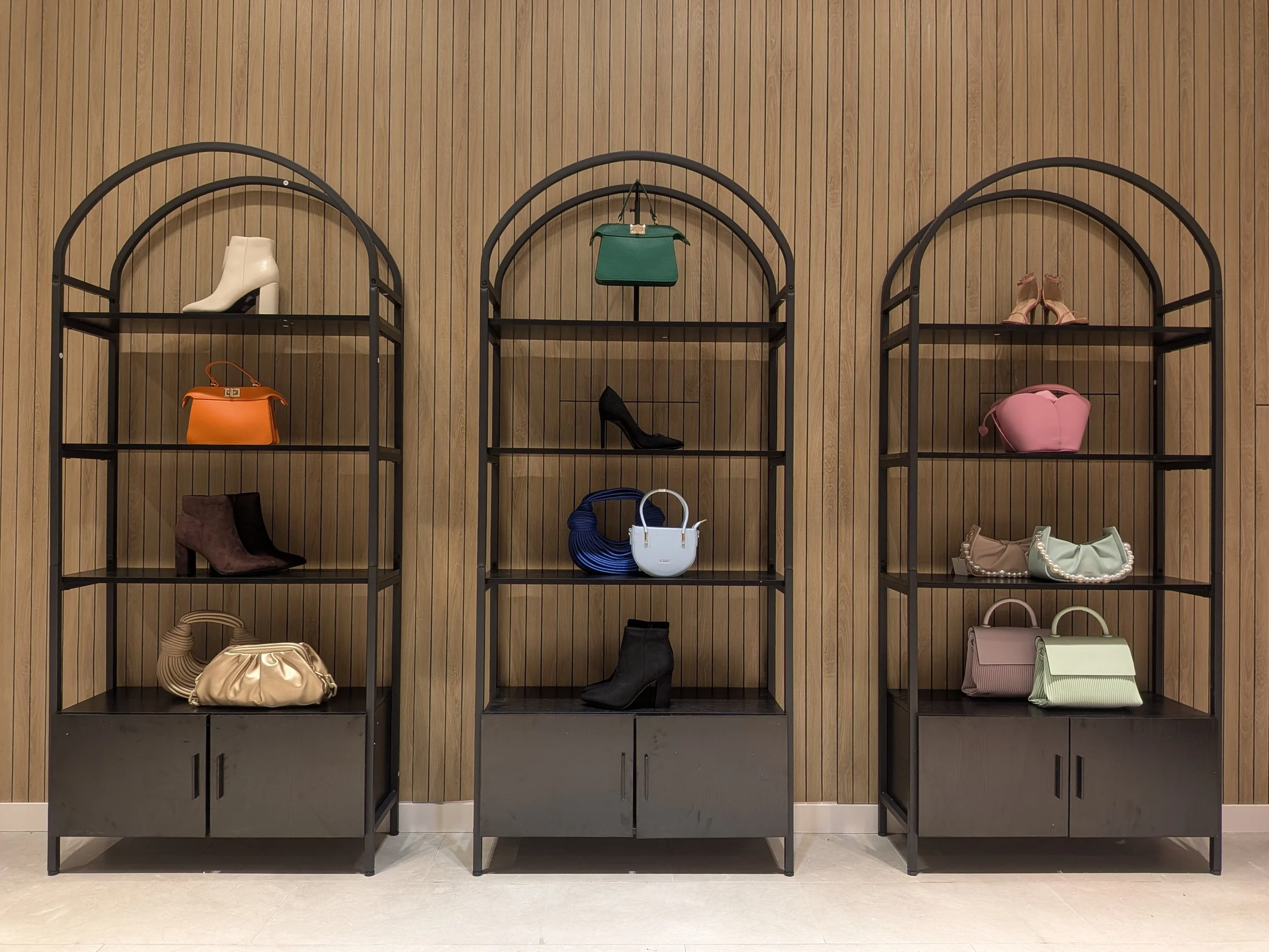 Boutique accessories wall display at Aimee Boutique featuring handbags and footwear organized through retail merchandising strategy.