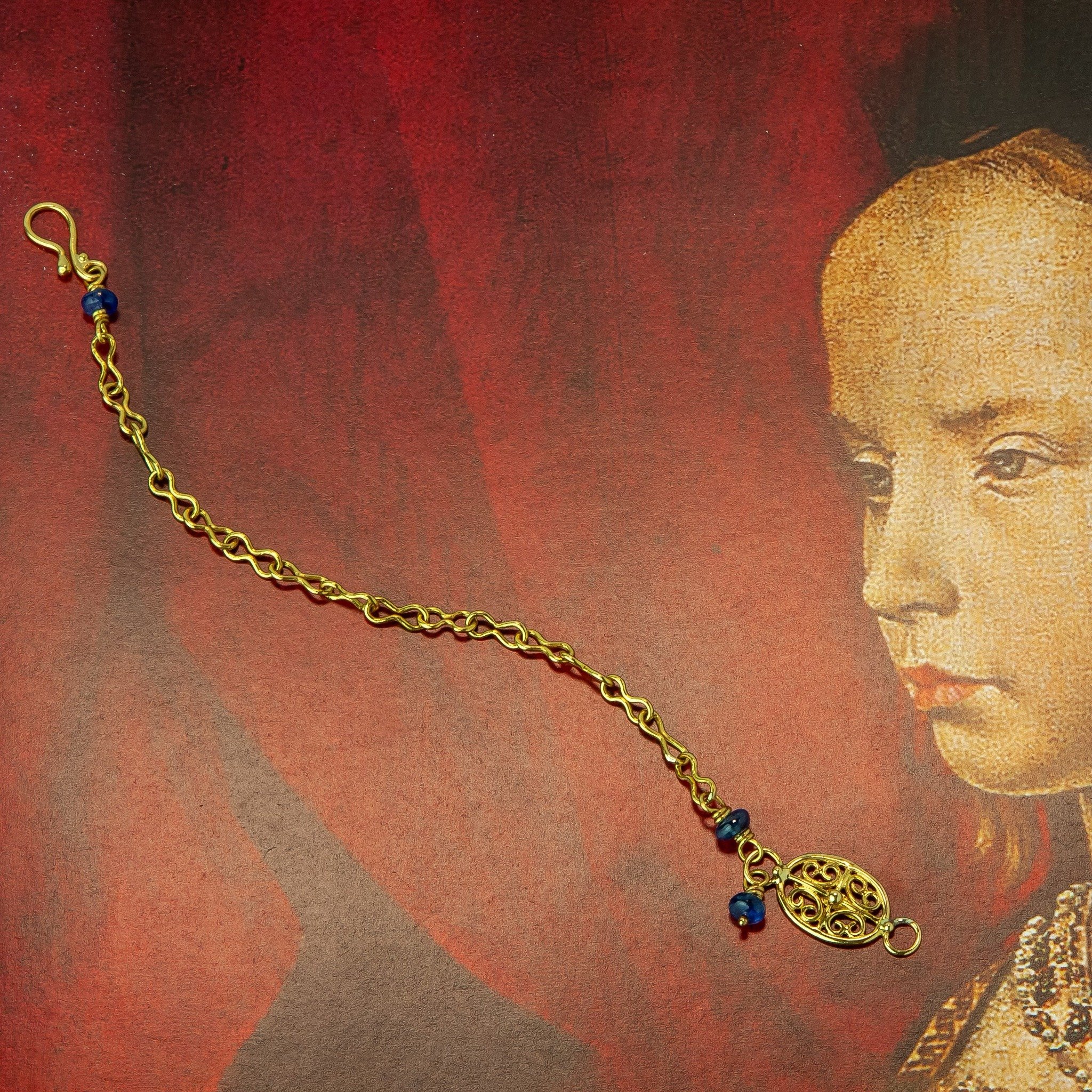Blue sapphire and 22-karat gold bracelet handcrafted in NYC. Shown on a detail of the Portinari Altarpiece.