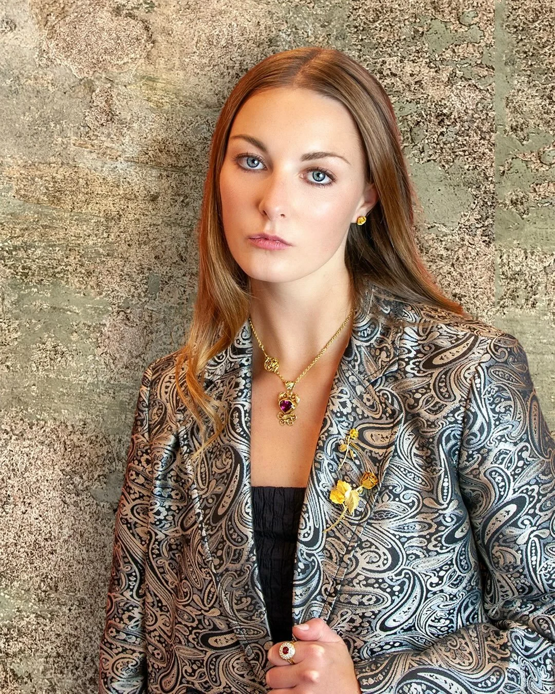 Gold with an Edge.

Against an ancient Umbrian stone wall, Carolyn wears our handcrafted &ldquo;Lady Sarah Innes Rose&rdquo; brooches, made with custom 22-karat gold alloys, our &ldquo;Roma&rdquo; chain necklace also in 22-karat gold, and our &ldquo;
