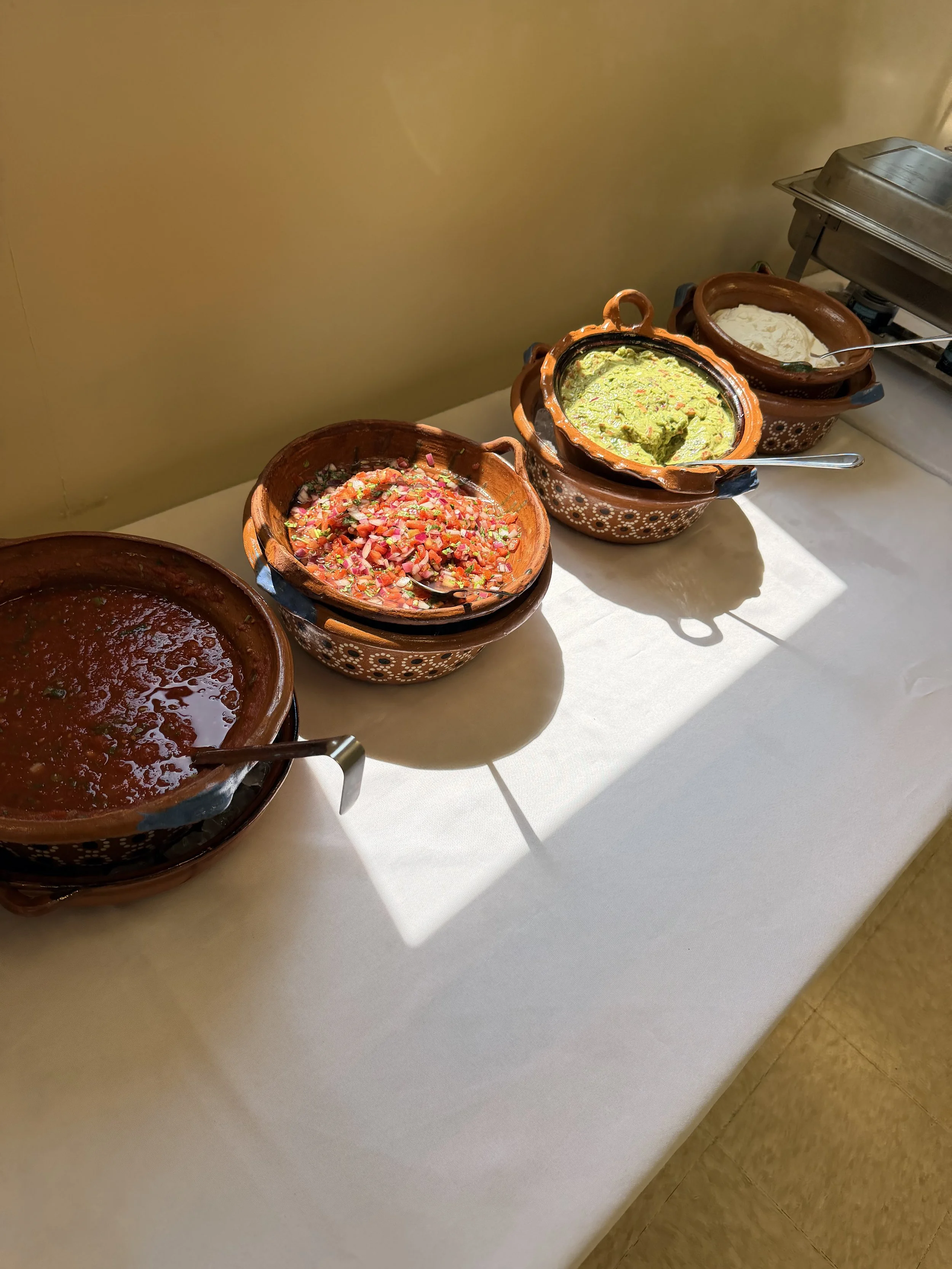 Don Jockey catering buffet featuring house salsa, pico de galo, guacamolr and sour cream served in traditional Mexican pottery.