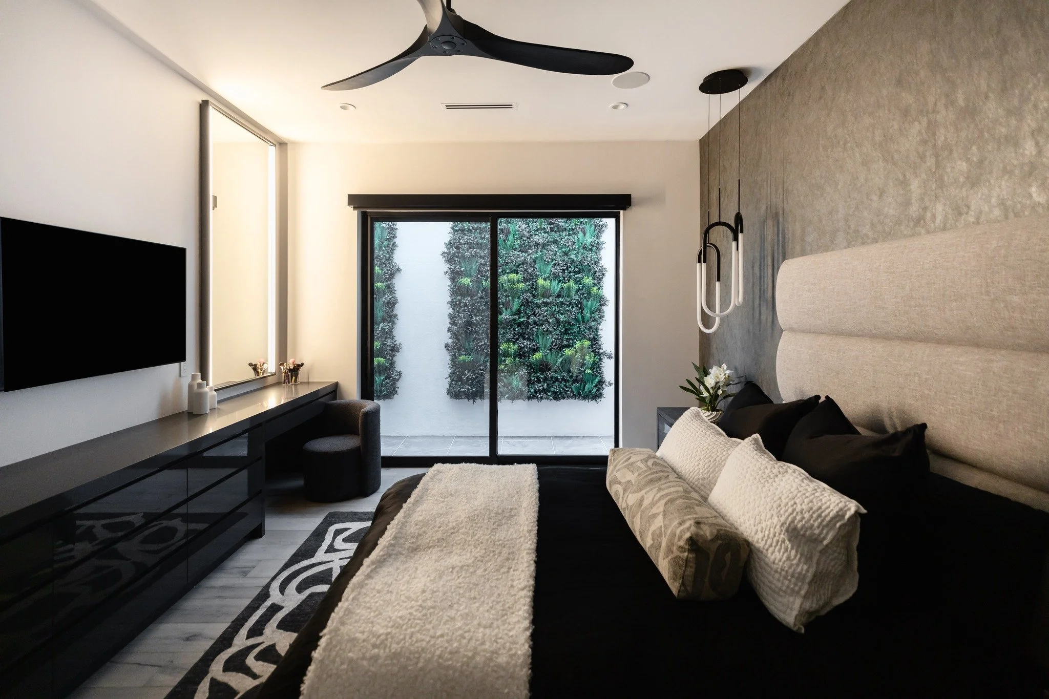 Moody. Modern. Made-to-measure.

Custom details include a boucle vanity stool, tailored bed frame, built-in millwork featured with a lighted mirror.  Design is grounded by an abstract rug and softened by a green wall that transforms the basement wind