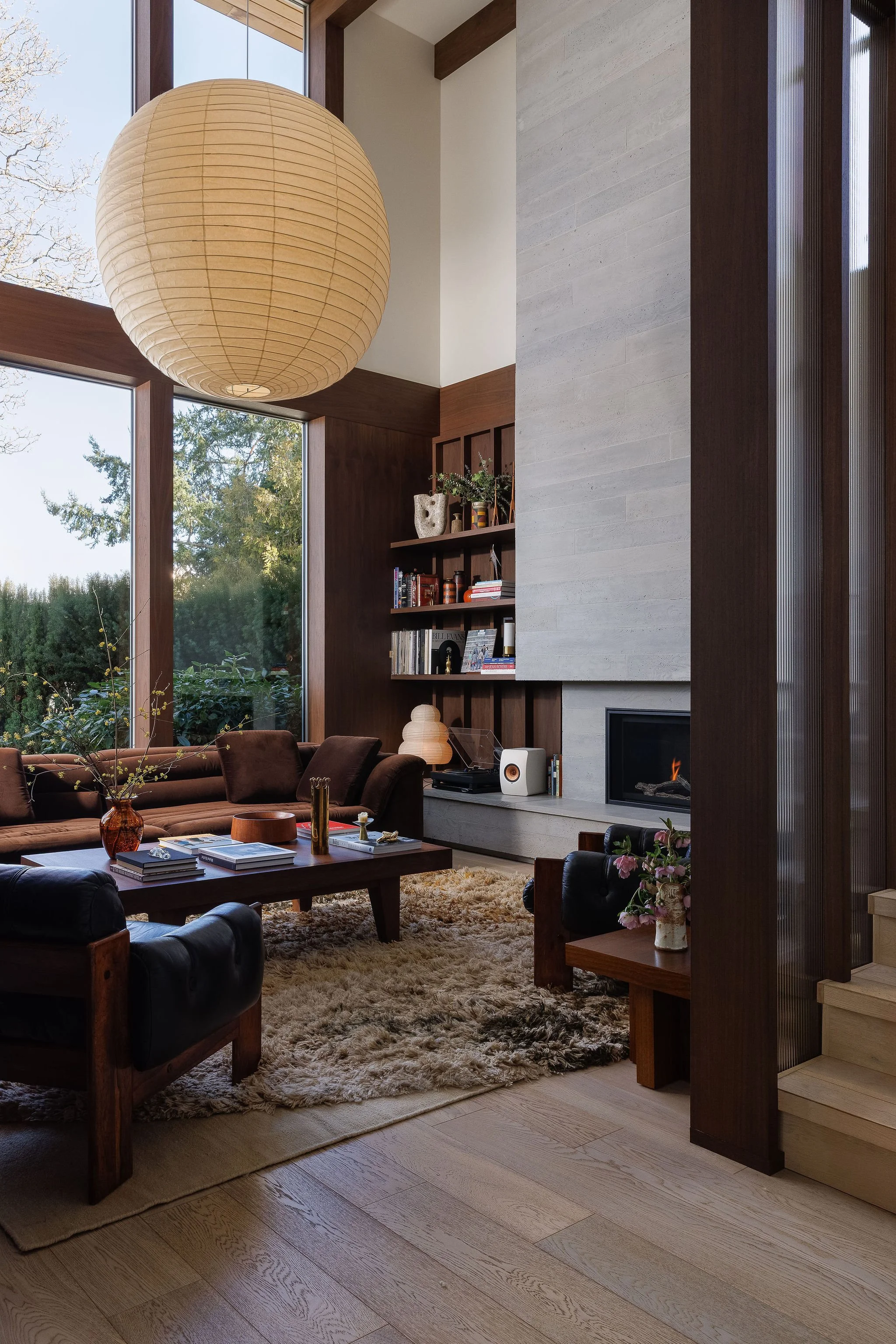 Residential living room featuring a statement fireplace and expansive glazing in Victoria BC by Little Giant