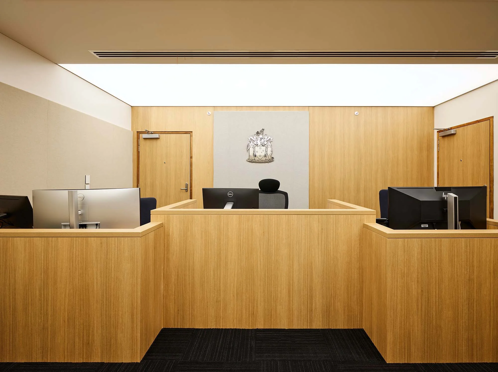 Symmetrical courtroom bench with dual side stations, timber panelling and coat of arms