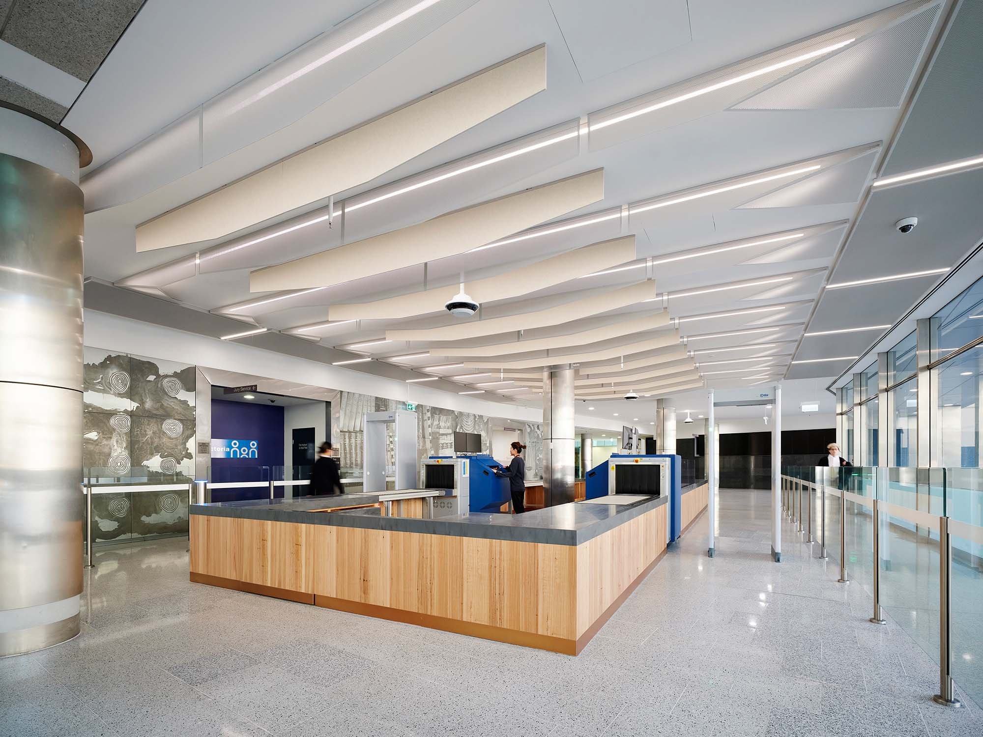 Court foyer with timber-clad security desk, X-ray scanners