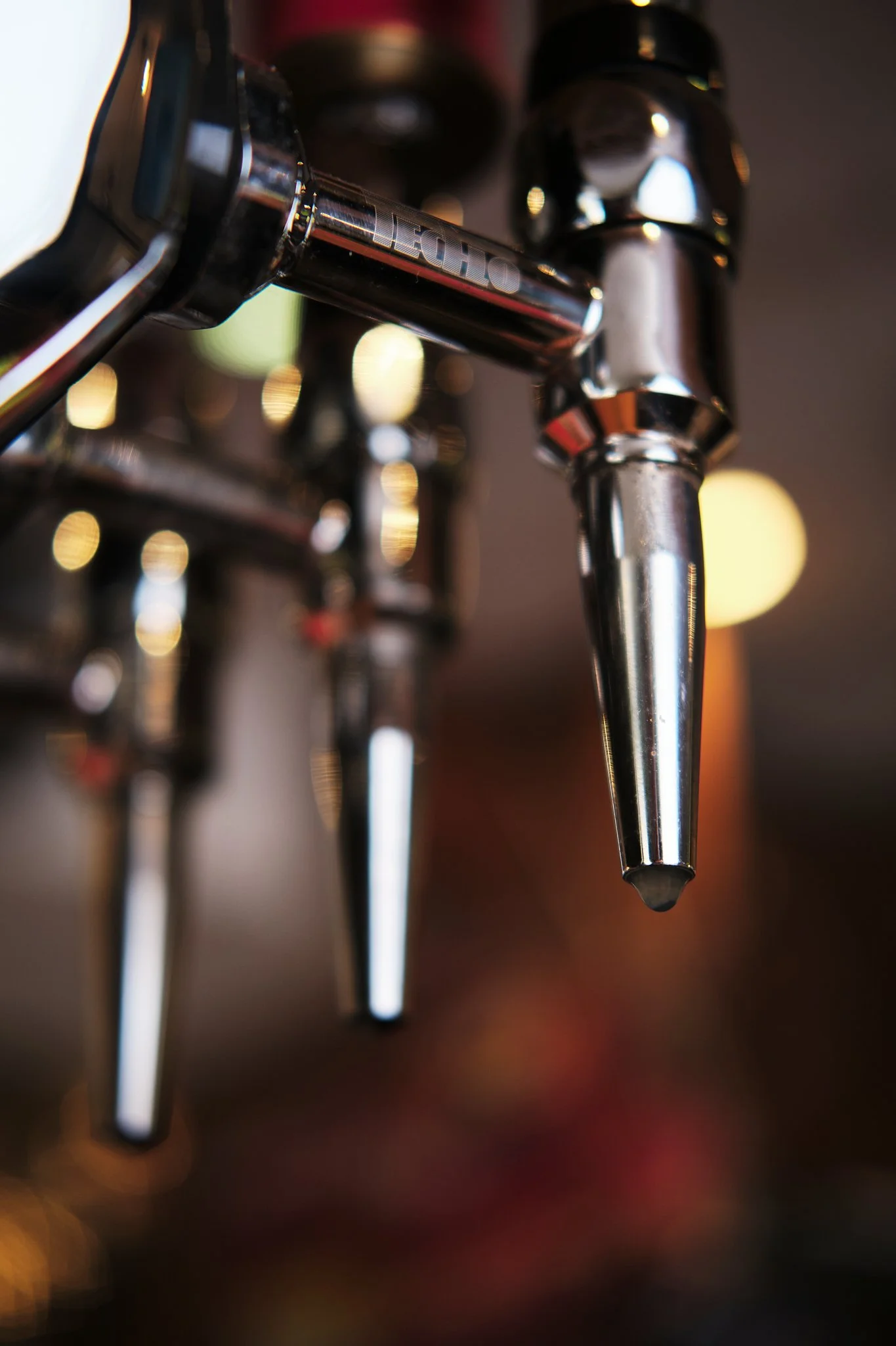 Close-up of a shiny coffee machine espresso spout.