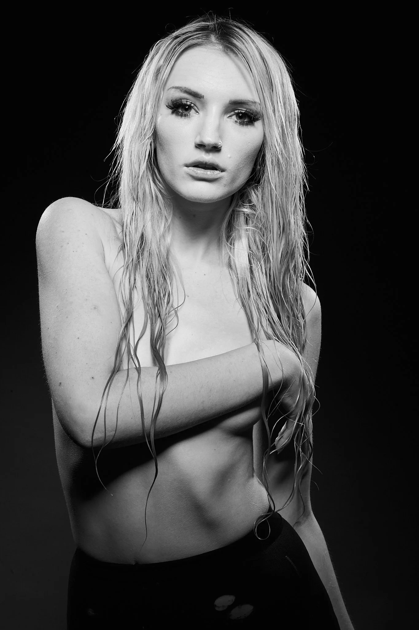 Black and white portrait of a woman with wet hair covering her chest, looking at the camera with a neutral expression.