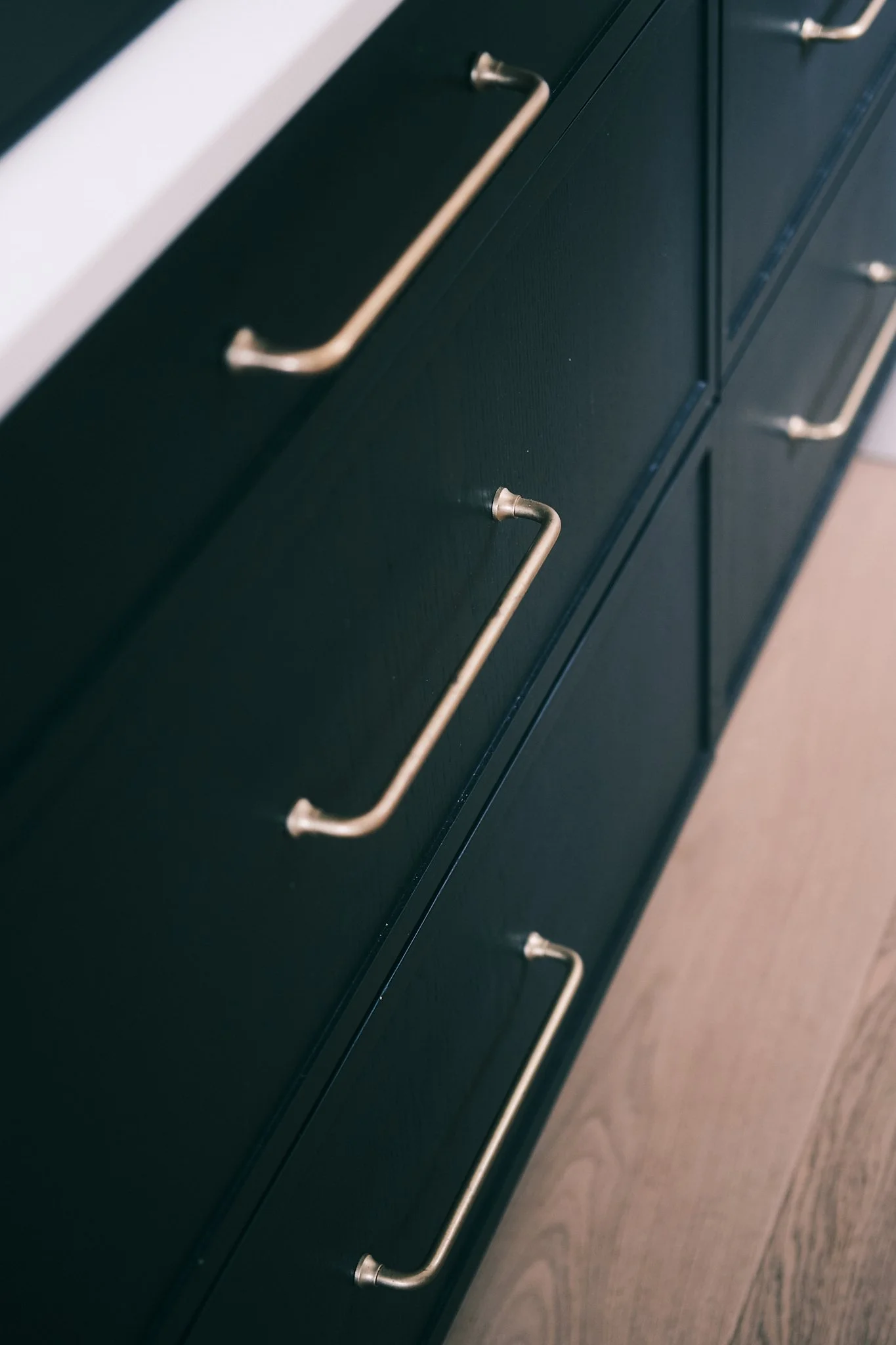 Close-up of a black cabinet with silver handles, mounted on a wall.