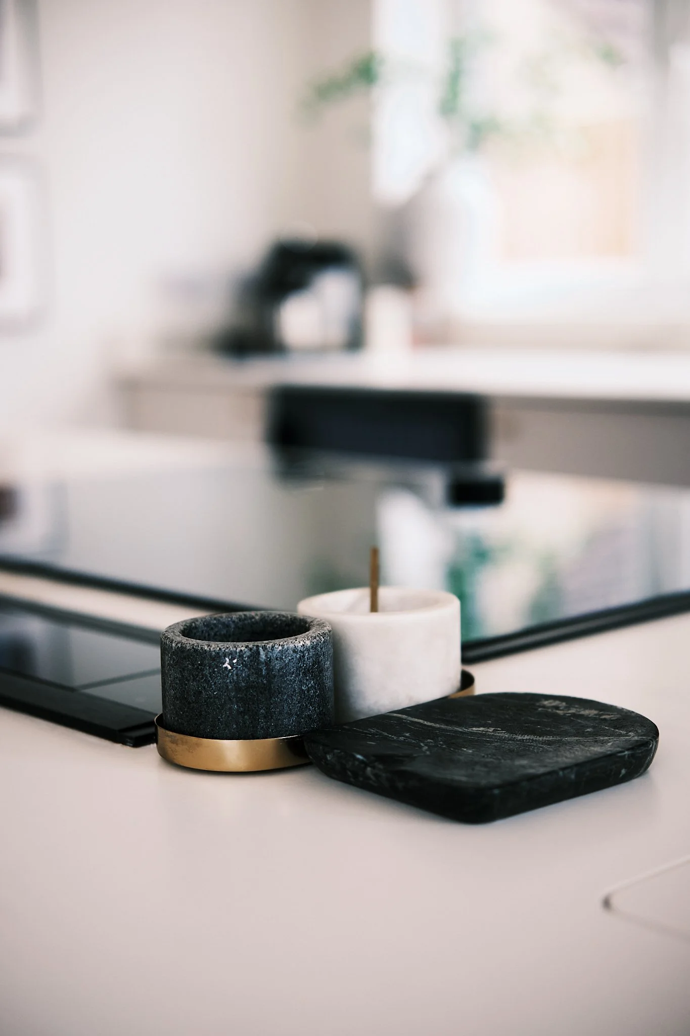 Decorative items on a kitchen countertop including black and white candle holders and a black marble tray.
