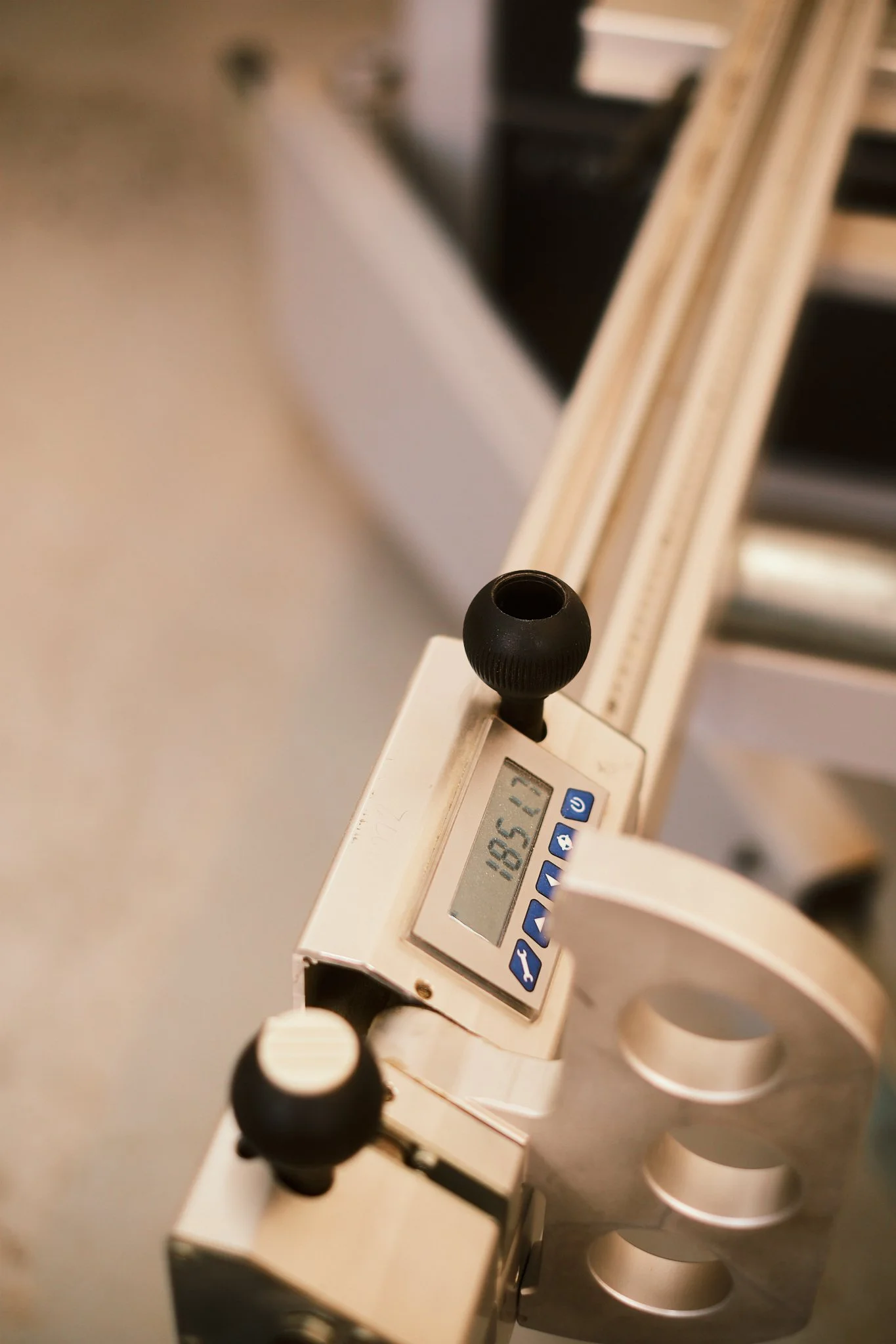 A digital precision scale with a small black spherical metal weight on top, displaying a weight of 55.41 grams.