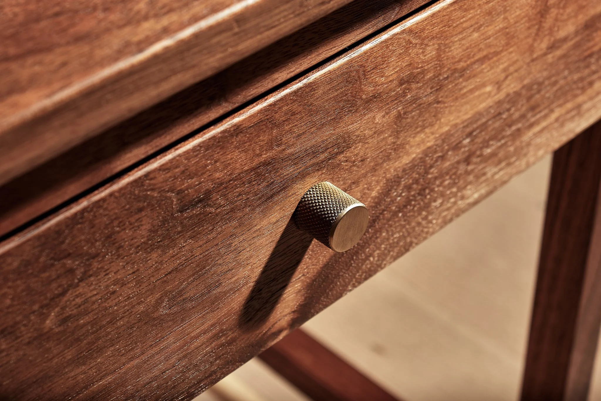 Close-up of a wooden drawer with a textured metal knob.
