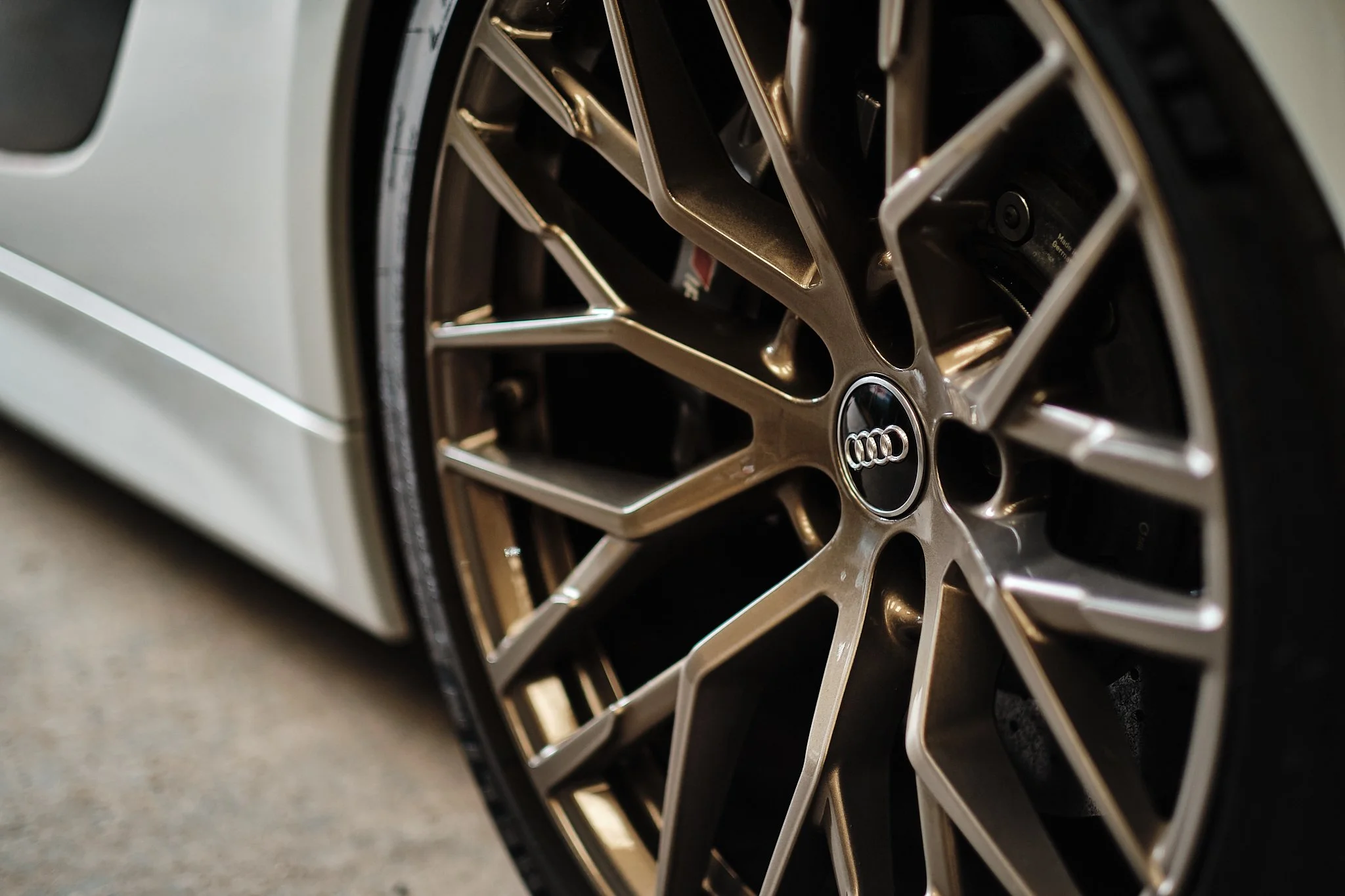 Close-up of an Audi car wheel with a metallic rim and black tire.