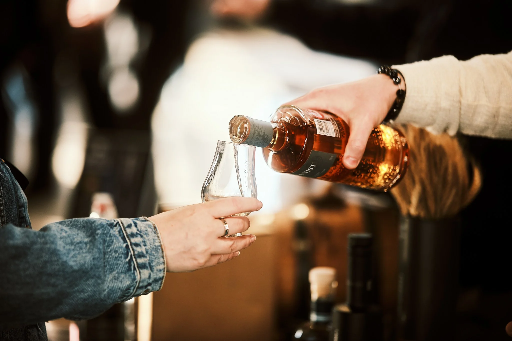 Person pouring whiskey into a glass