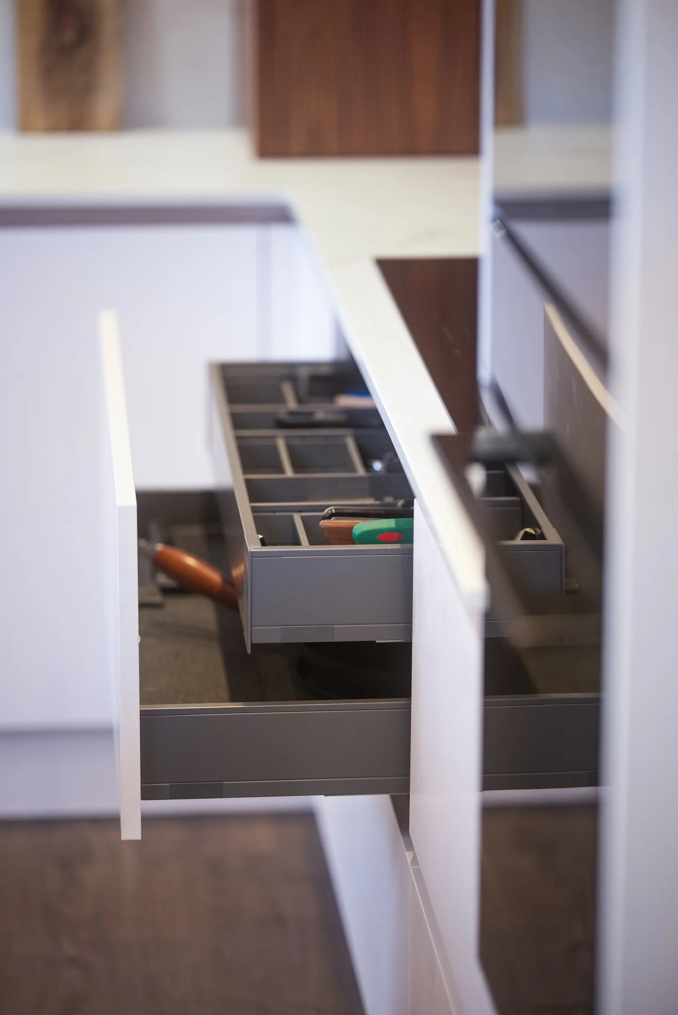 Open kitchen drawer with utensils inside.