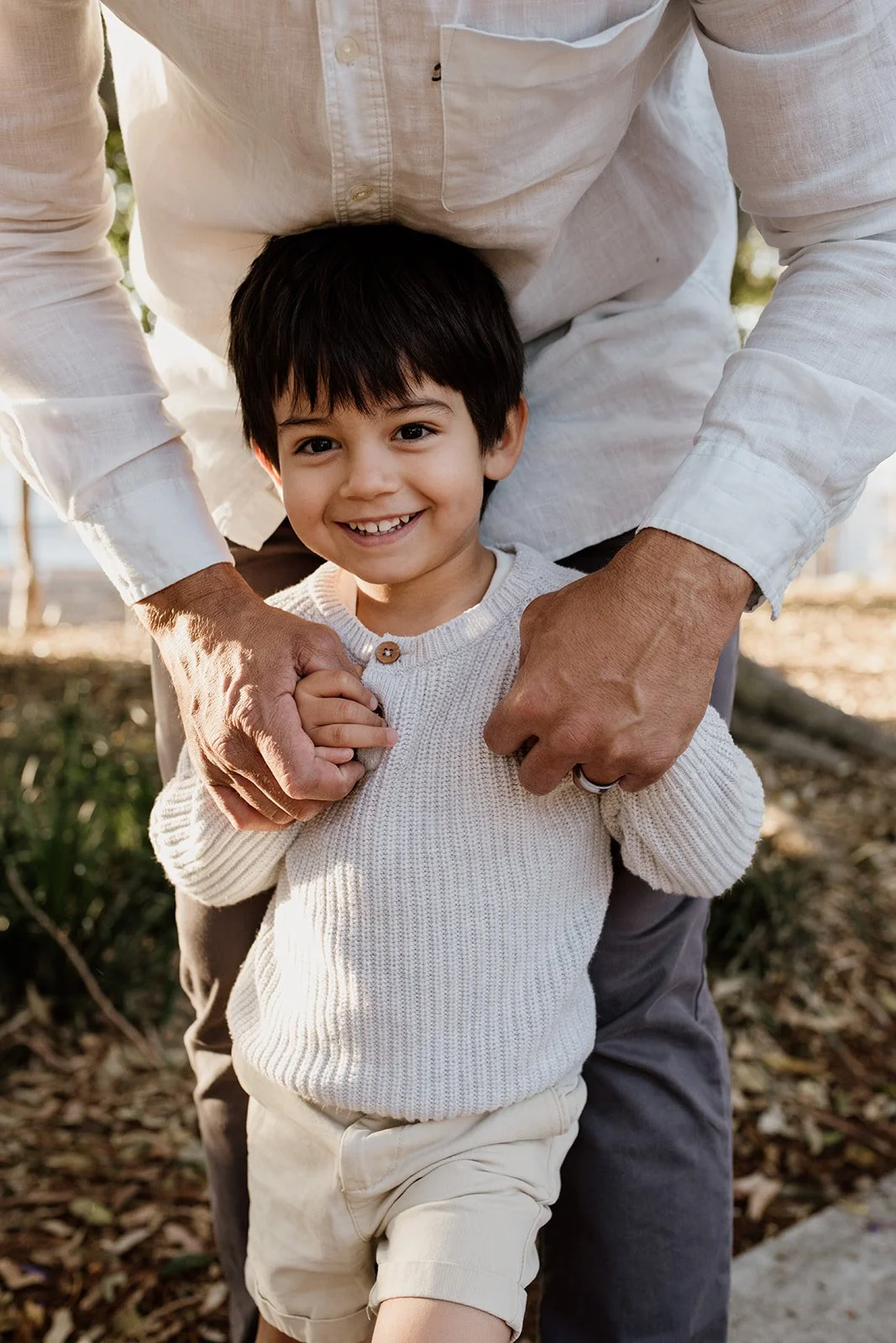 Young boy smiles at camera by Gold Coast family photographer.