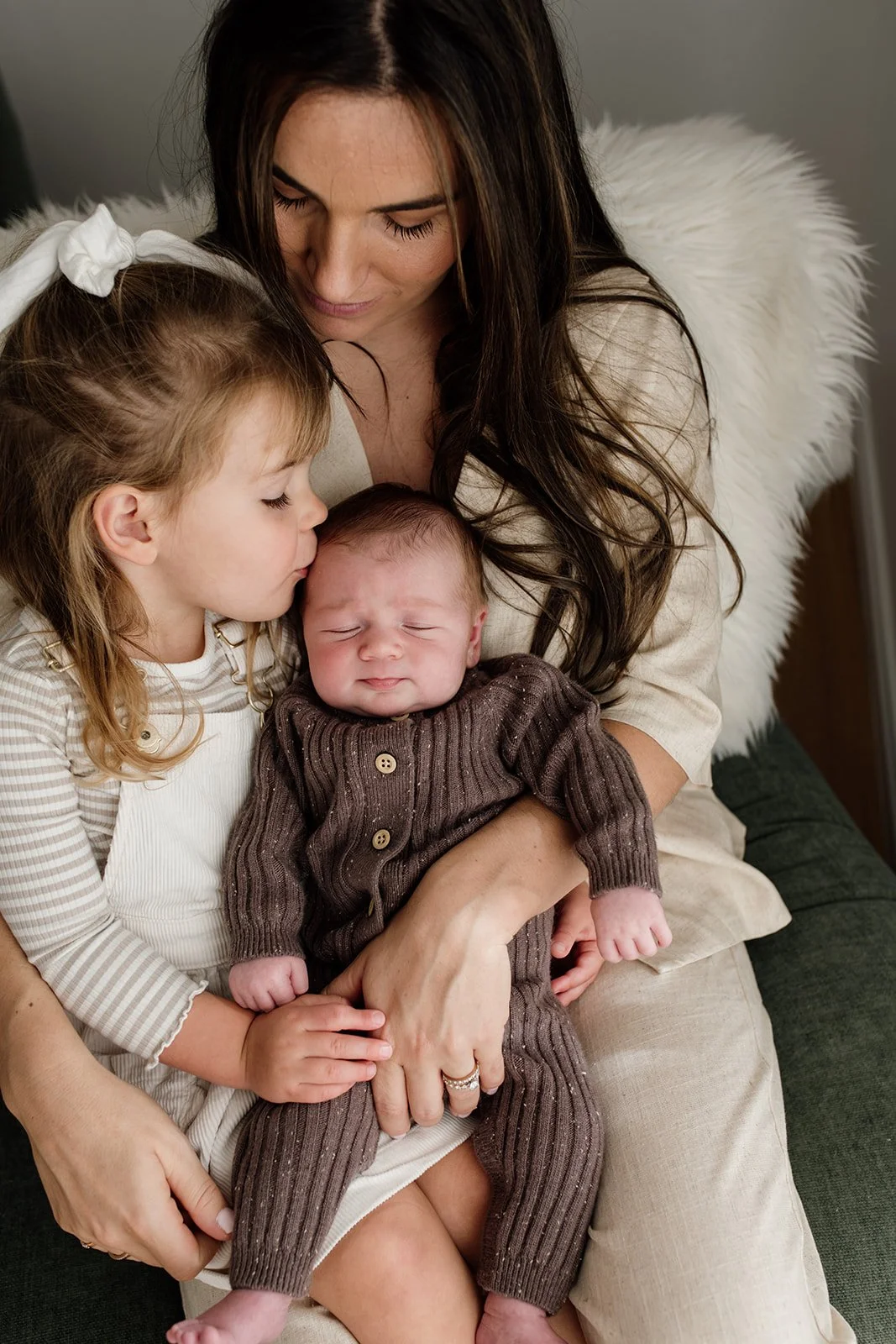 Byron Bay family photographer captures mother and two children together on the couch during Byron Bay newborn photography shoot. 