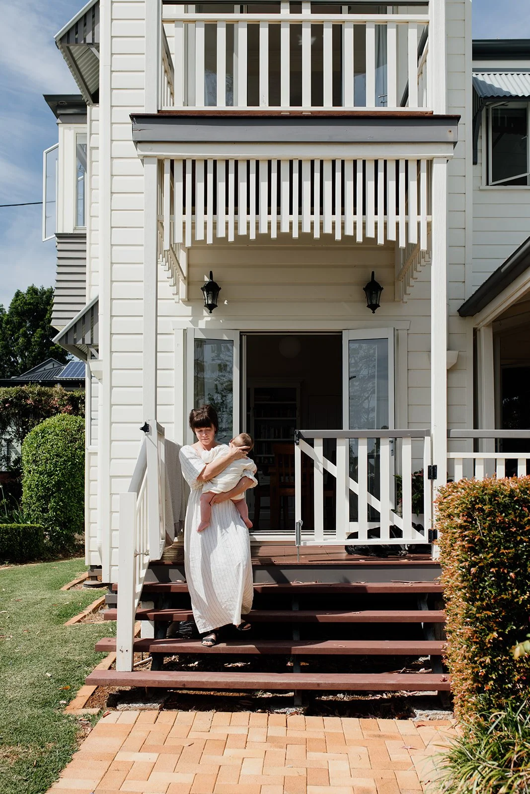 Gold Coast family photography portraits at home where mother walks young baby around the house. 