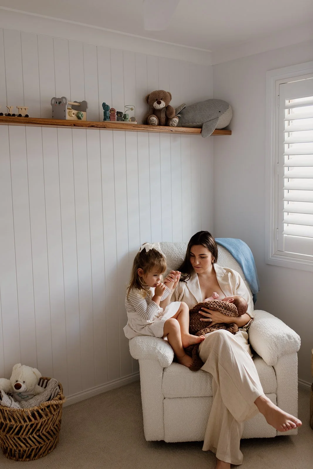 Byron Bay family photographer captures mother and two children together on the couch during Byron Bay newborn photography shoot.