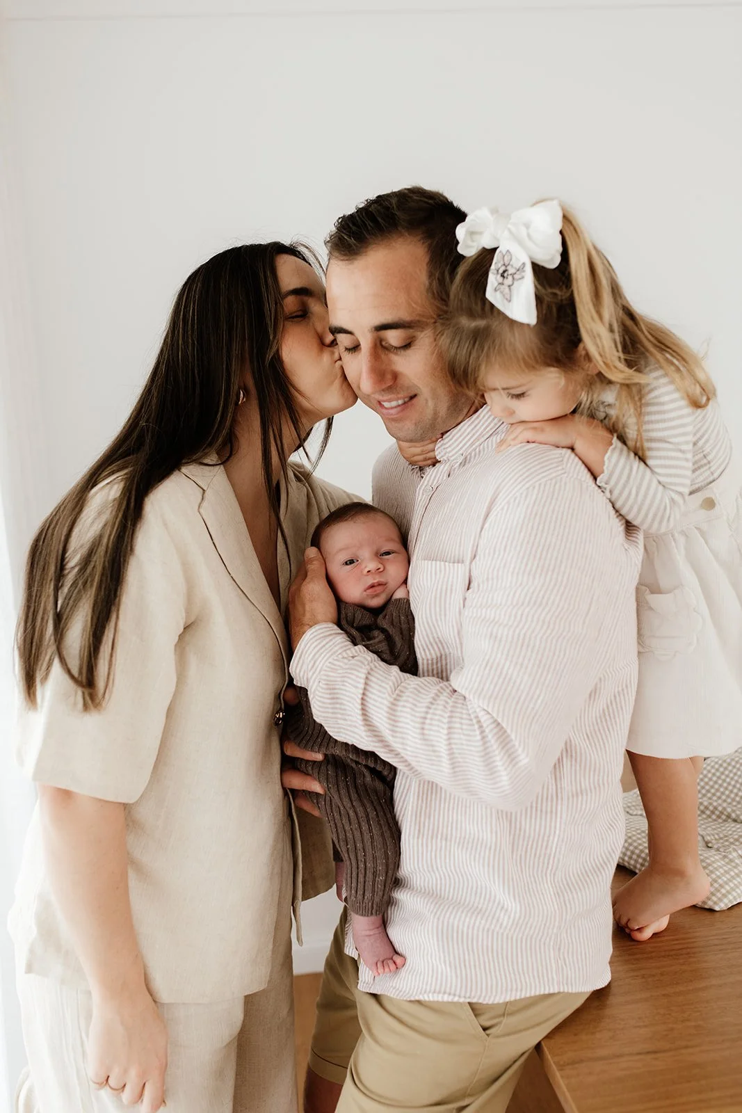 Northern Rivers newborn photography session with family by the window cuddling new baby, during Northern Rivers newborn photography shoot.