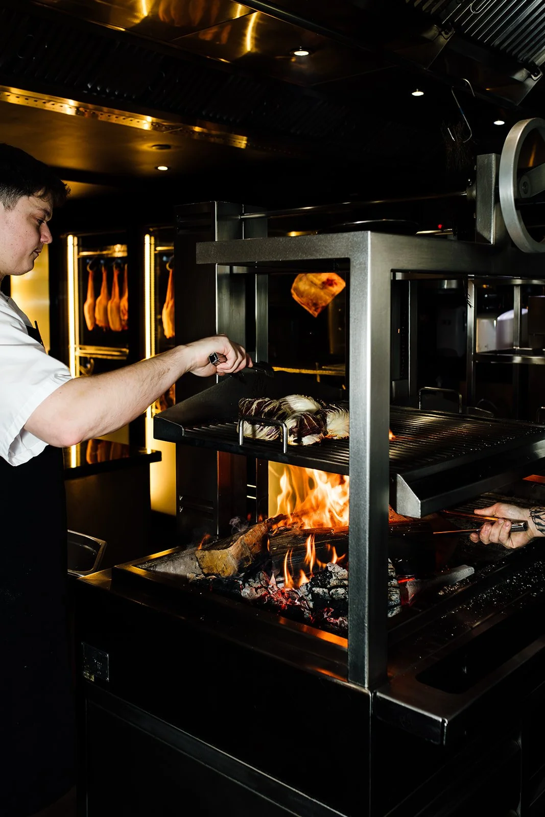 Gold Coast restaurant photographer captures chef cooking over open grill at Nineteen at the Star during Gold Coast restaurant photography session.