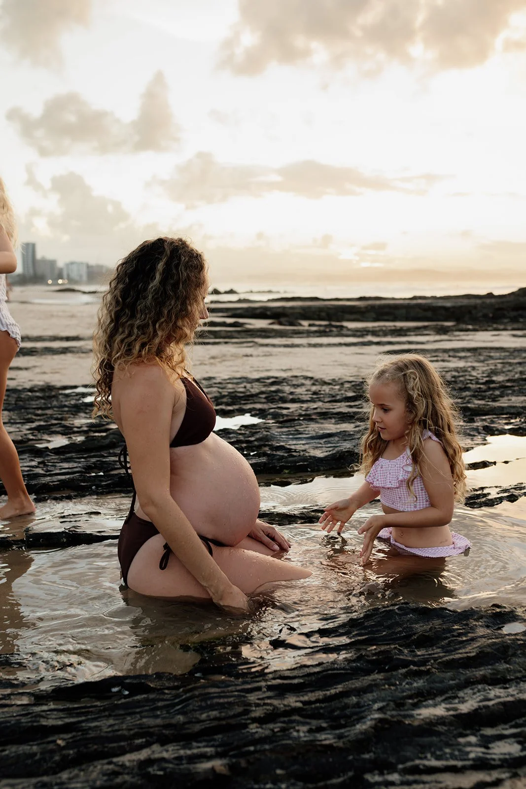 Gold Coast maternity photographer captures mum and daughter in rock pools during Gold Coast maternity photo shoot. 