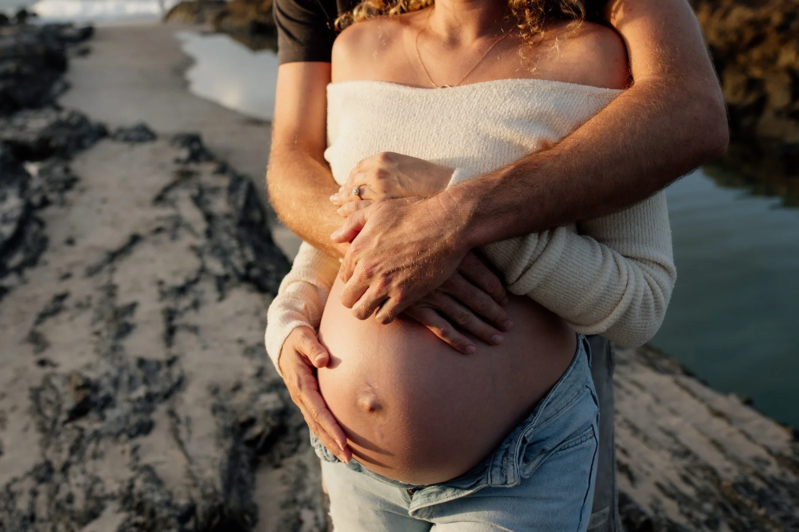 Gold Coast maternity photo shoot with young couple at the beach holding bump.