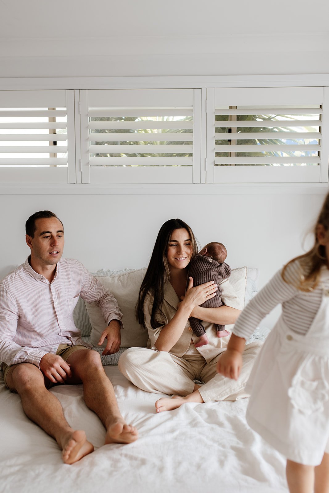 Tweed Coast newborn photography session at home with family playing on the bed.