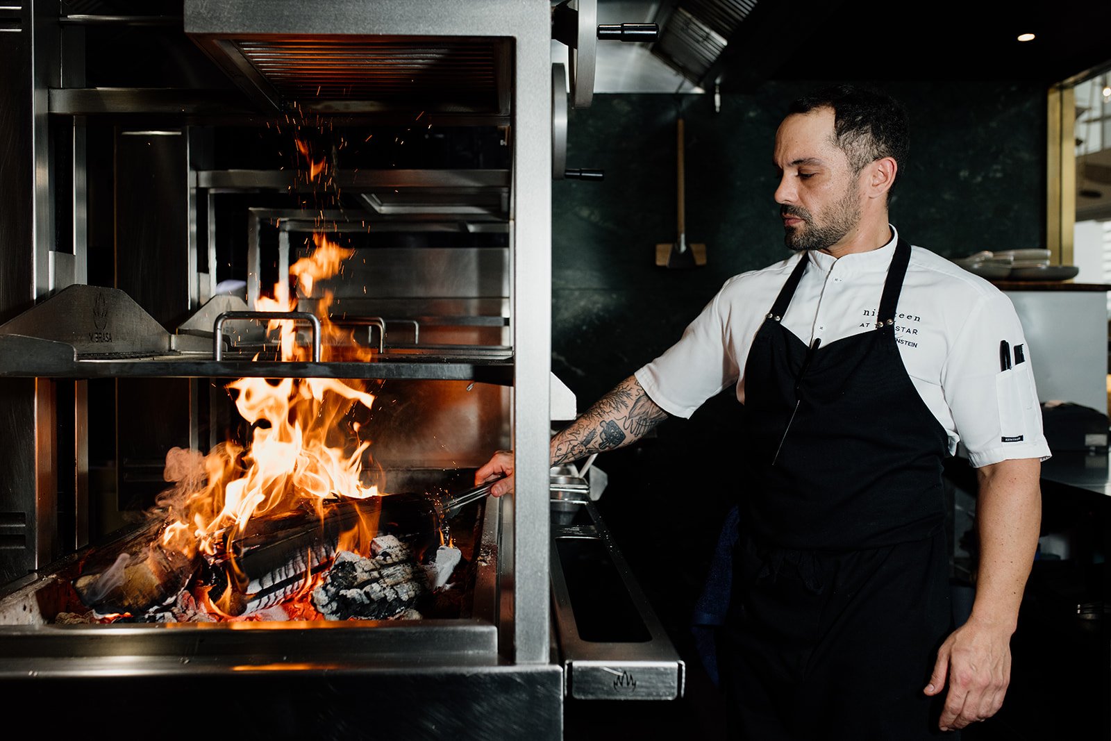 Gold Coast restaurant photographer captures chef working over an open grill during Gold Coast restaurant photography shoot. 