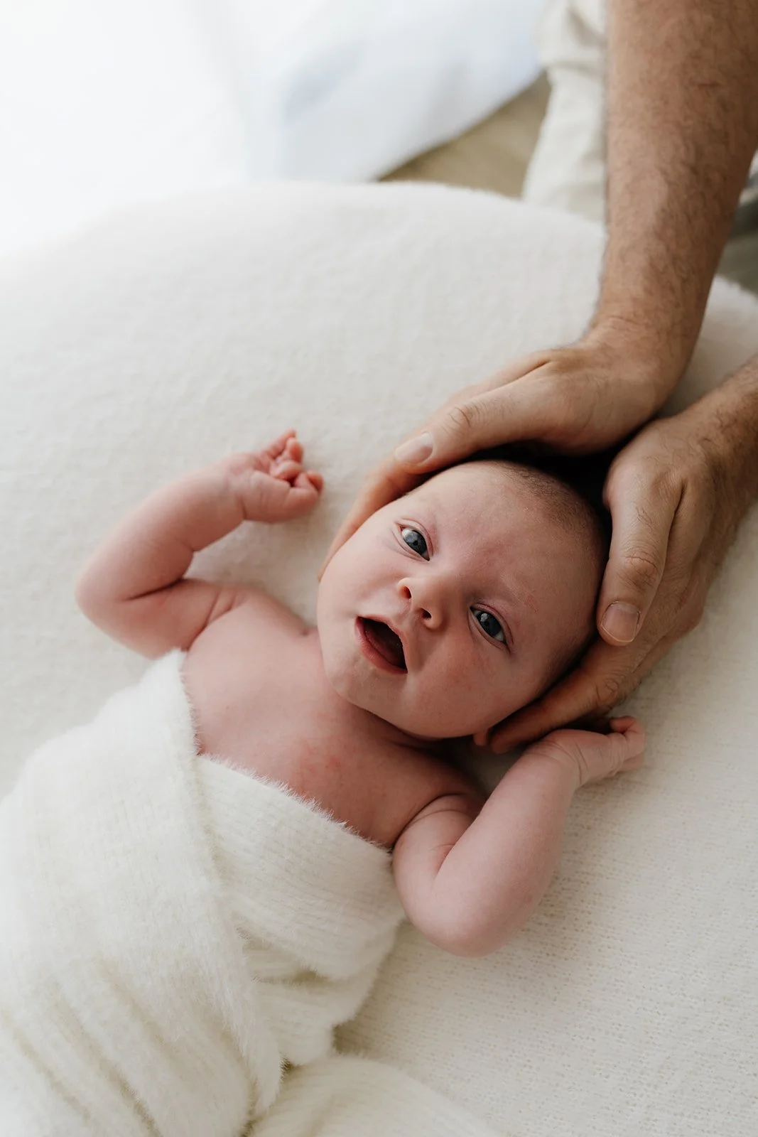 Byron Bay family photographer captures new baby at home on beanbag during baby photography shoot.