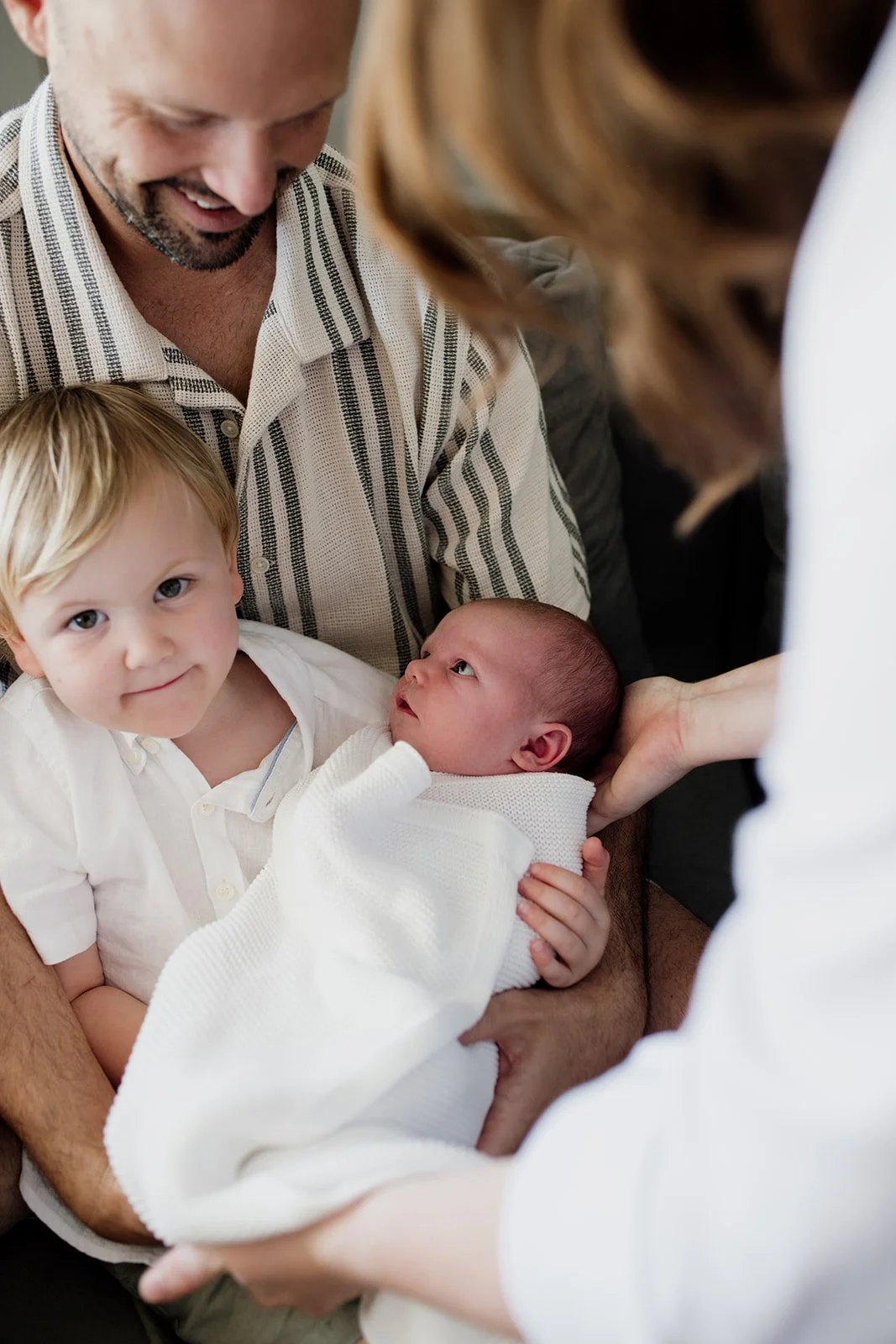 Byron Bay family photographer captures mother and two children together on the couch during Byron Bay newborn photography shoot.