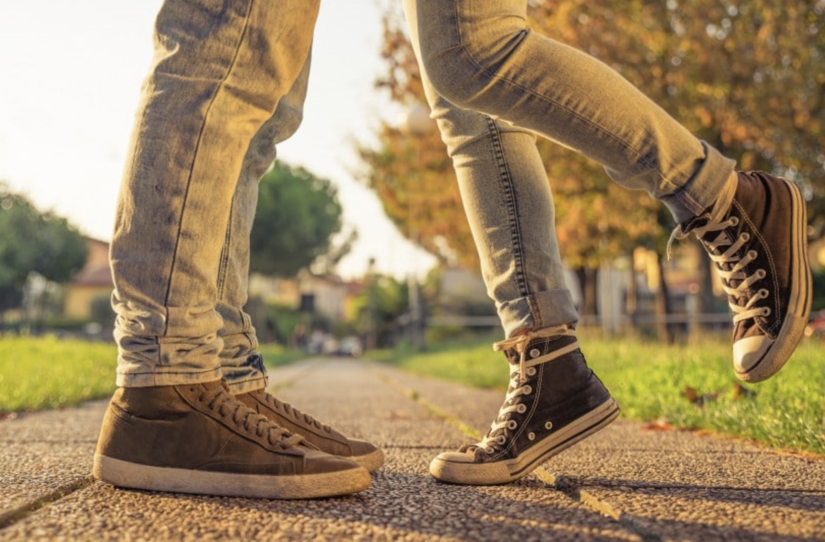 two humans who seem to be embracing, viewed from the knees down