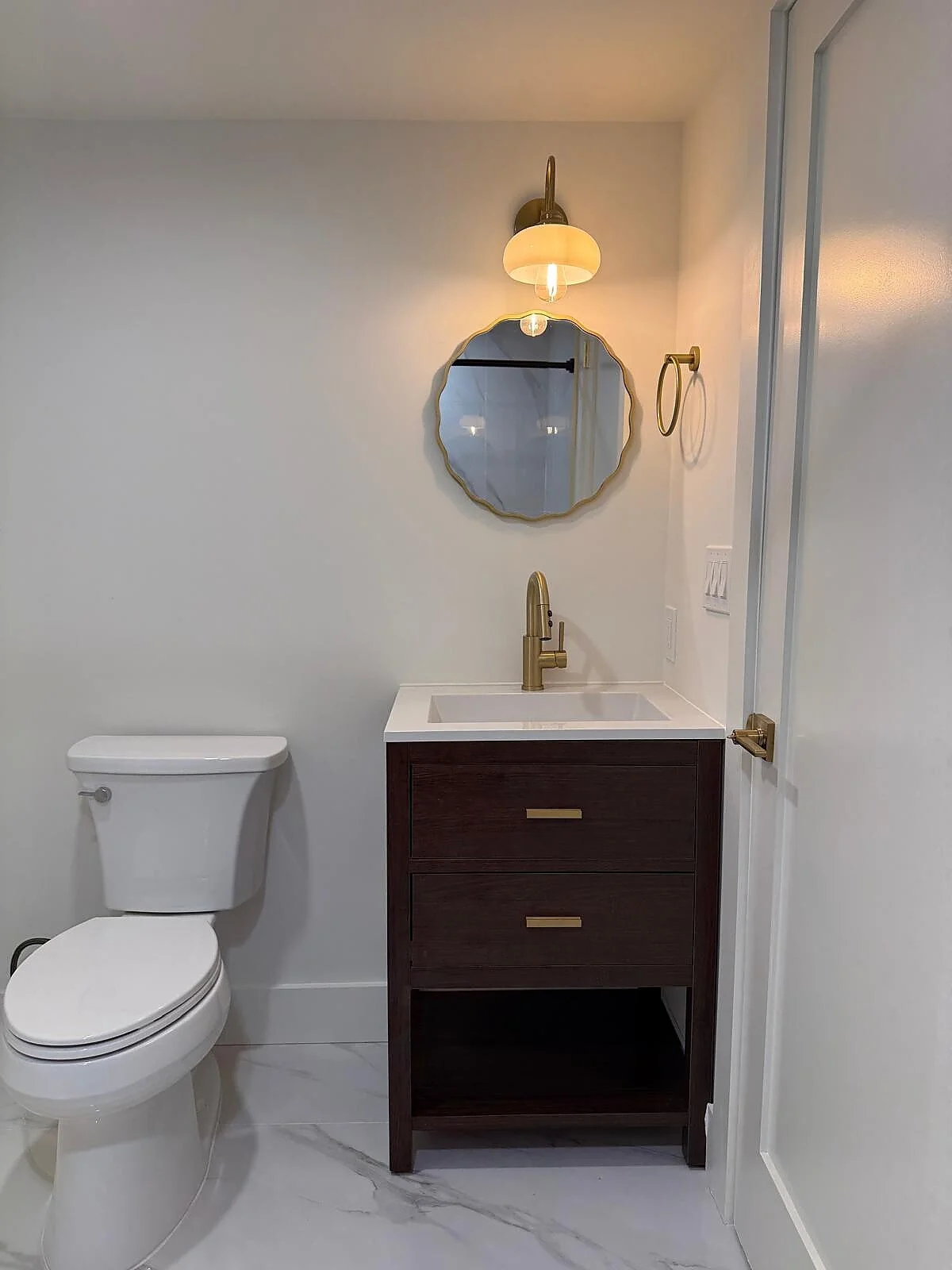 queens-court-13-powder-room-dark-vanity-round-mirror.jpg