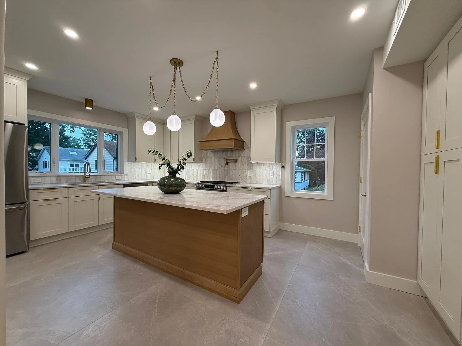 queens-court-01-kitchen-island-white-cabinets-brass-pendants.jpg