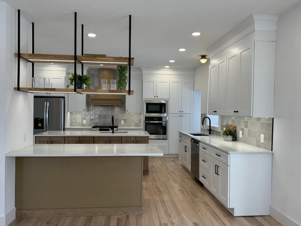 Merrison Street open kitchen with a large island, white cabinetry, wood range hood and hanging pot rack