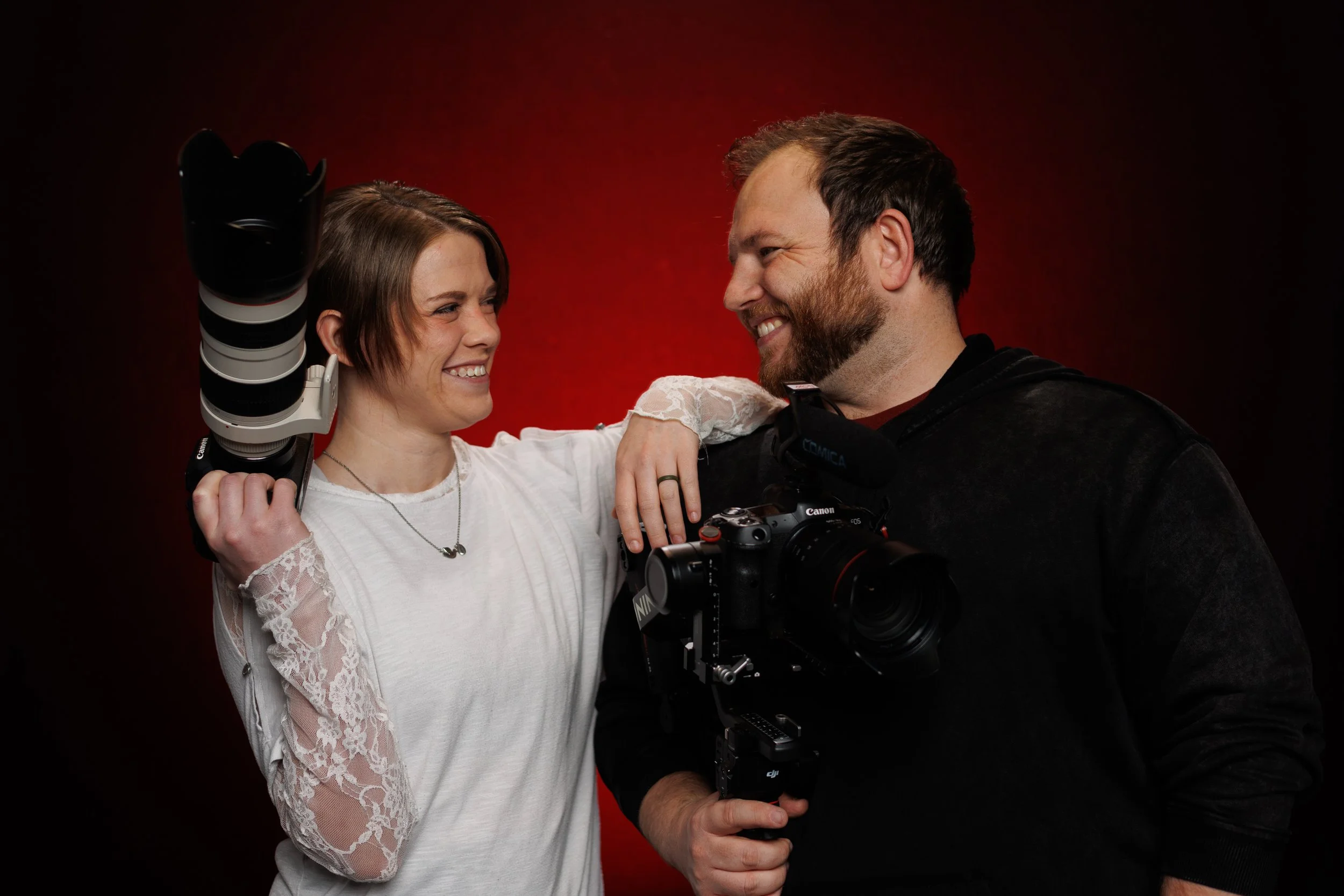 A wedding photography couple from Oklahoma City, holding professional cameras