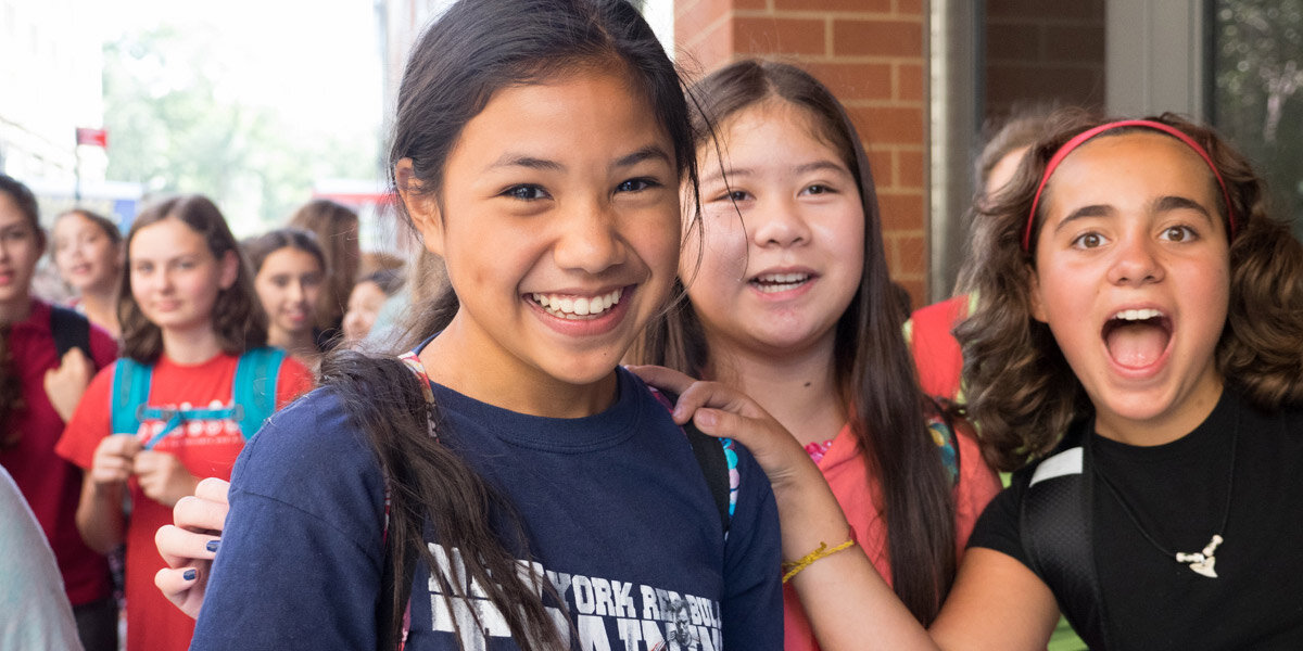 Smiling students outside of school