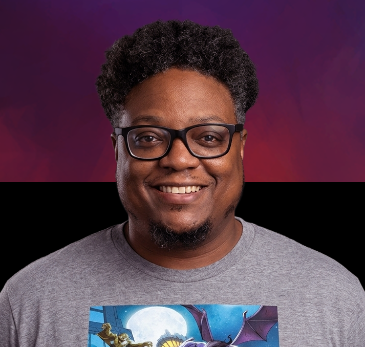 A smiling man with black glasses and curly hair, wearing a gray T-shirt, standing against a purple gradient background.