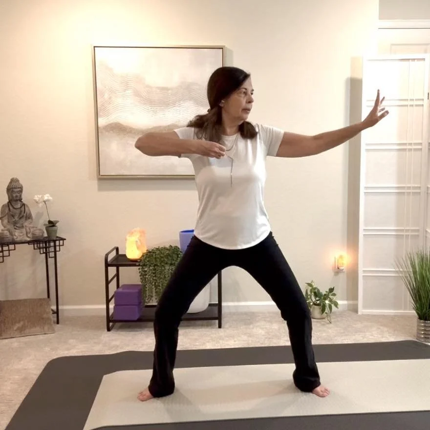 Monica practicing Qigong in a wide stance, arms extended in a bow and arrow shape, demonstrating a Ba Duan Jin movement.
