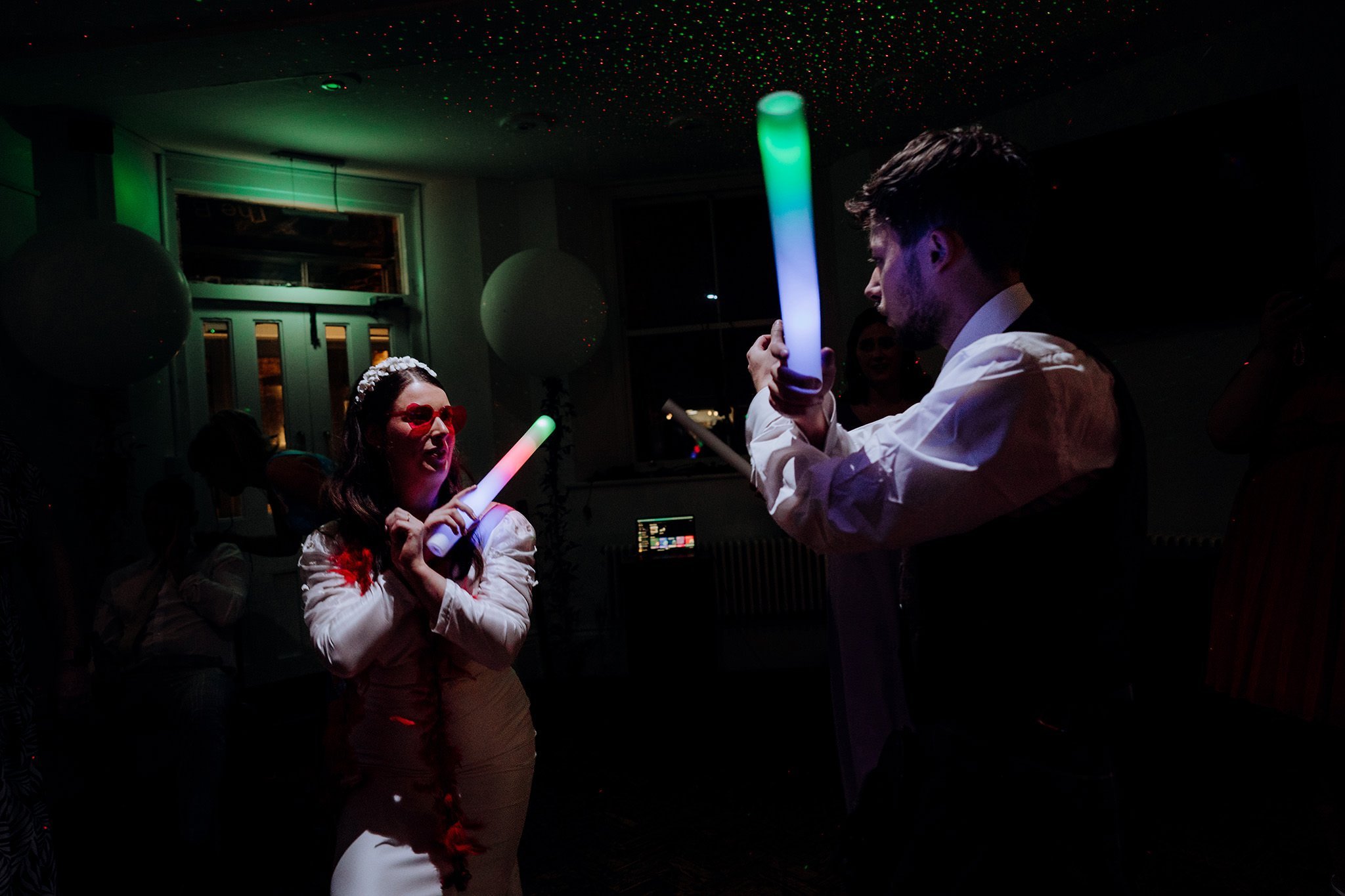 bride and groom dancing with light batons