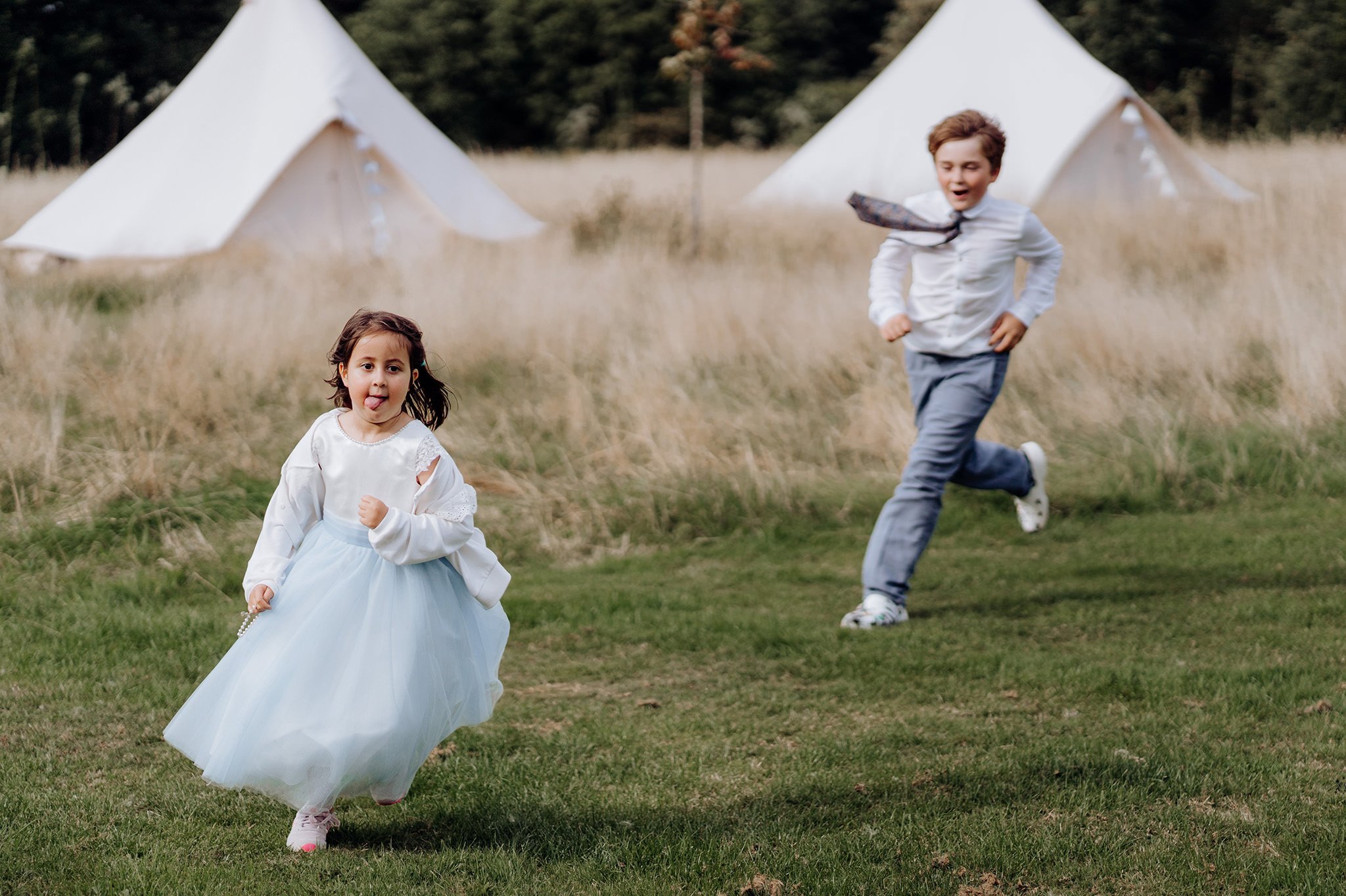 Young wedding guests chasing each other