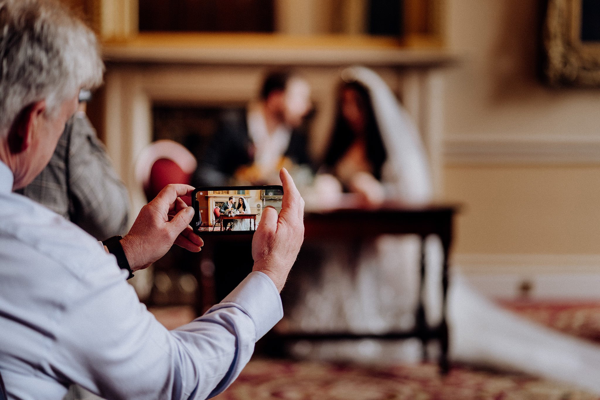 Guests snapping a shot of bride and groom, Liverpool Town Hall