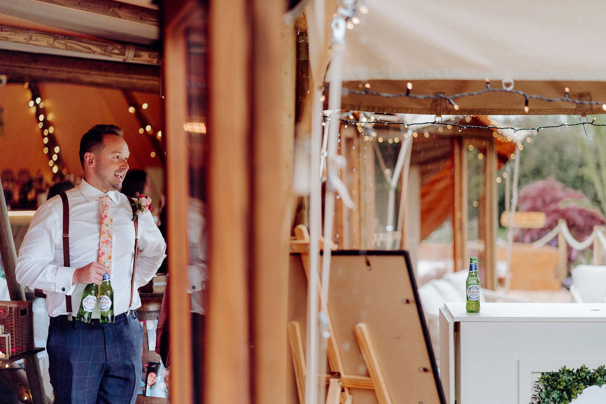 wedding guest sheltering from the rain at tipis at riley green